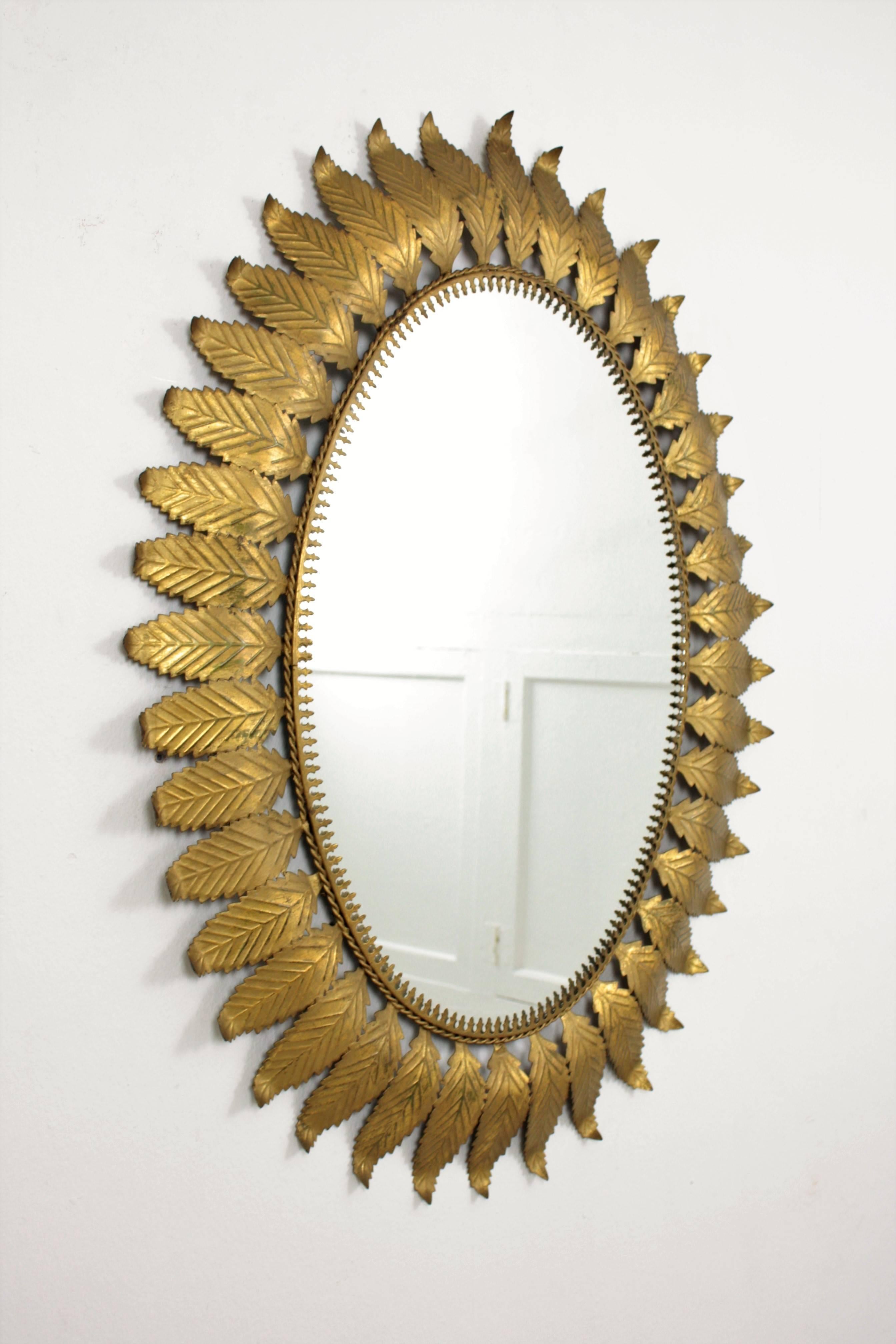 Mid-Century Modern gilt iron oval mirror framed with curved leaves. A handcrafted mirror with gilt patina manufactured in Spain at the 1960s. The large mirror surface makes this mirror a useful as well as.
Gorgeous placed alone in a powder room, in