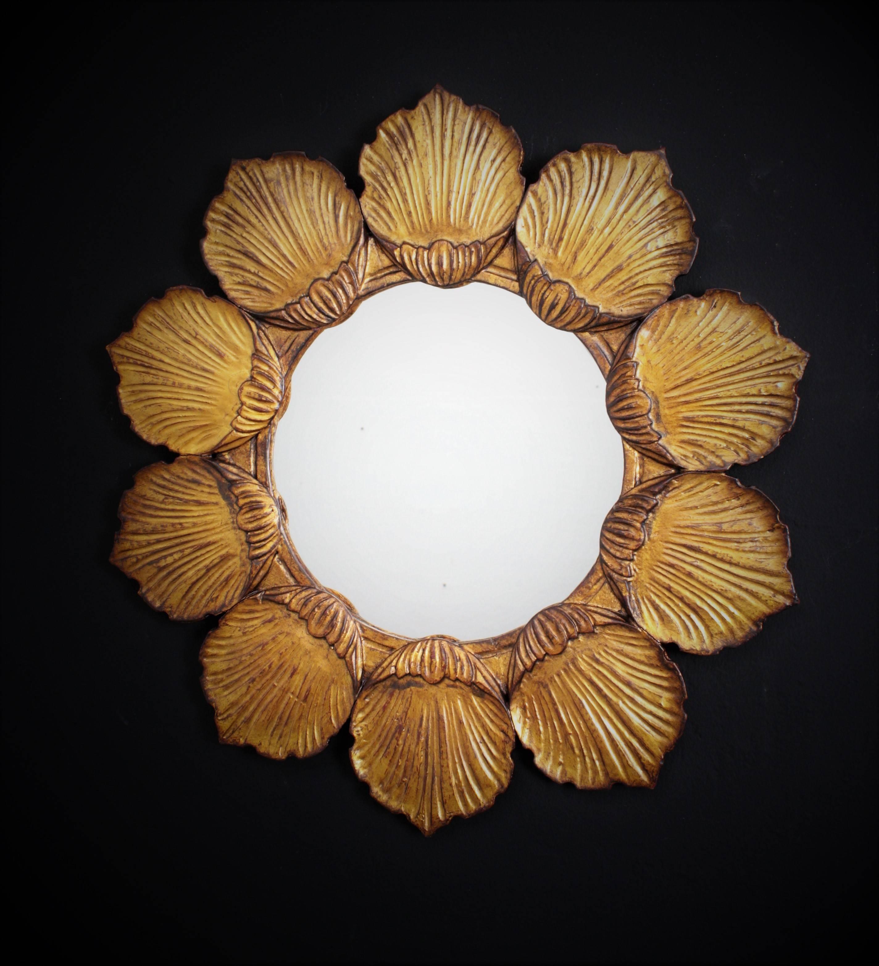Unique wood carved flower shaped mirror with gold leaf finish. A highly decorative piece with carved flower petals surrounding a circular glass with all the taste of Hollywood Regency style. Glass dimensions: 29 cm diameter.
France, 1950s.
Available