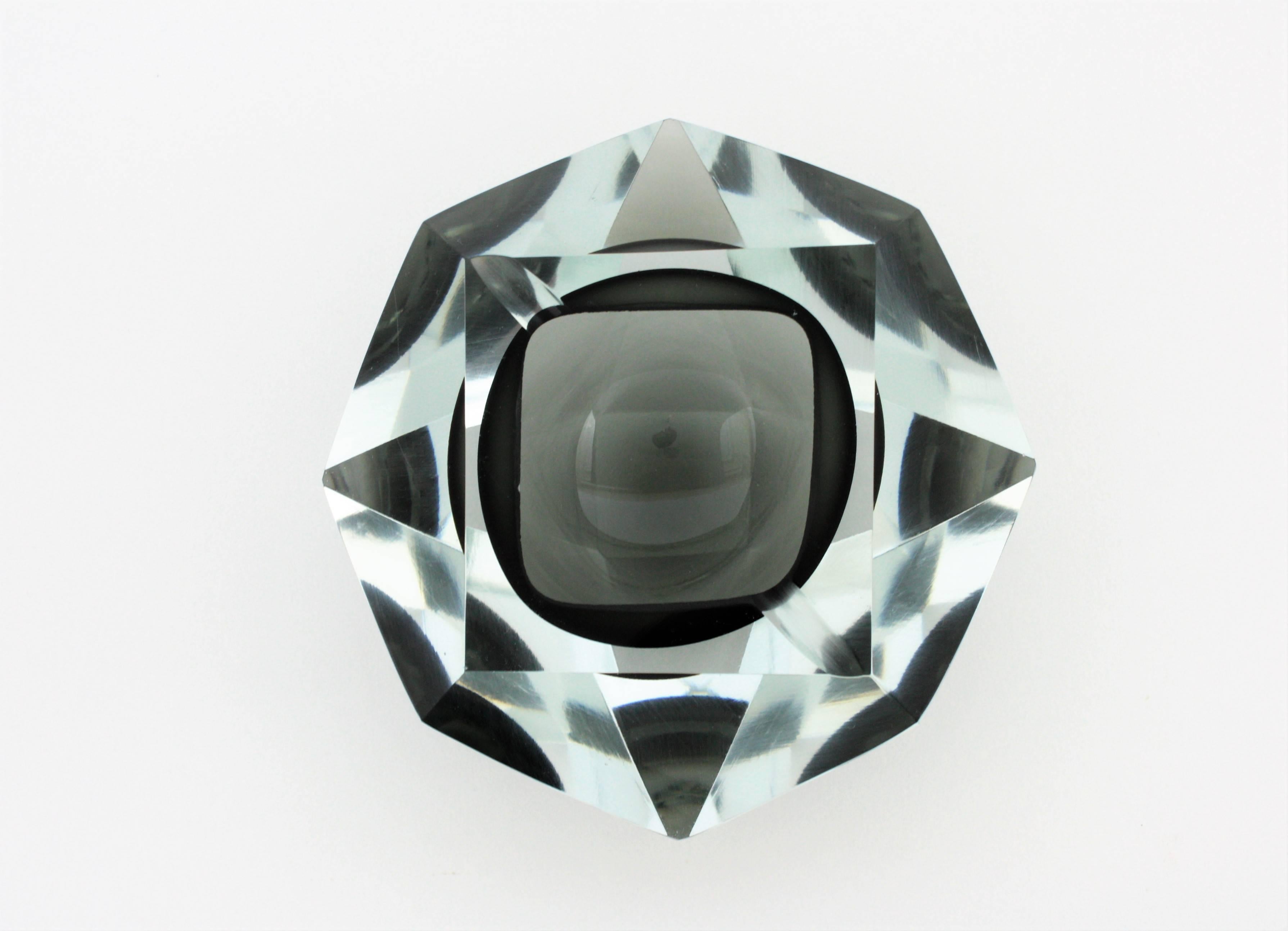 A beautiful smoked grey Sommerso faceted Murano glass astray attributed to Flavio Poli. Grey glass cased into clear glass and a highly decorative 12 faced geometric design.
Useful as bowl, ashtray, jewelry bowl or paperweight,
Italy,