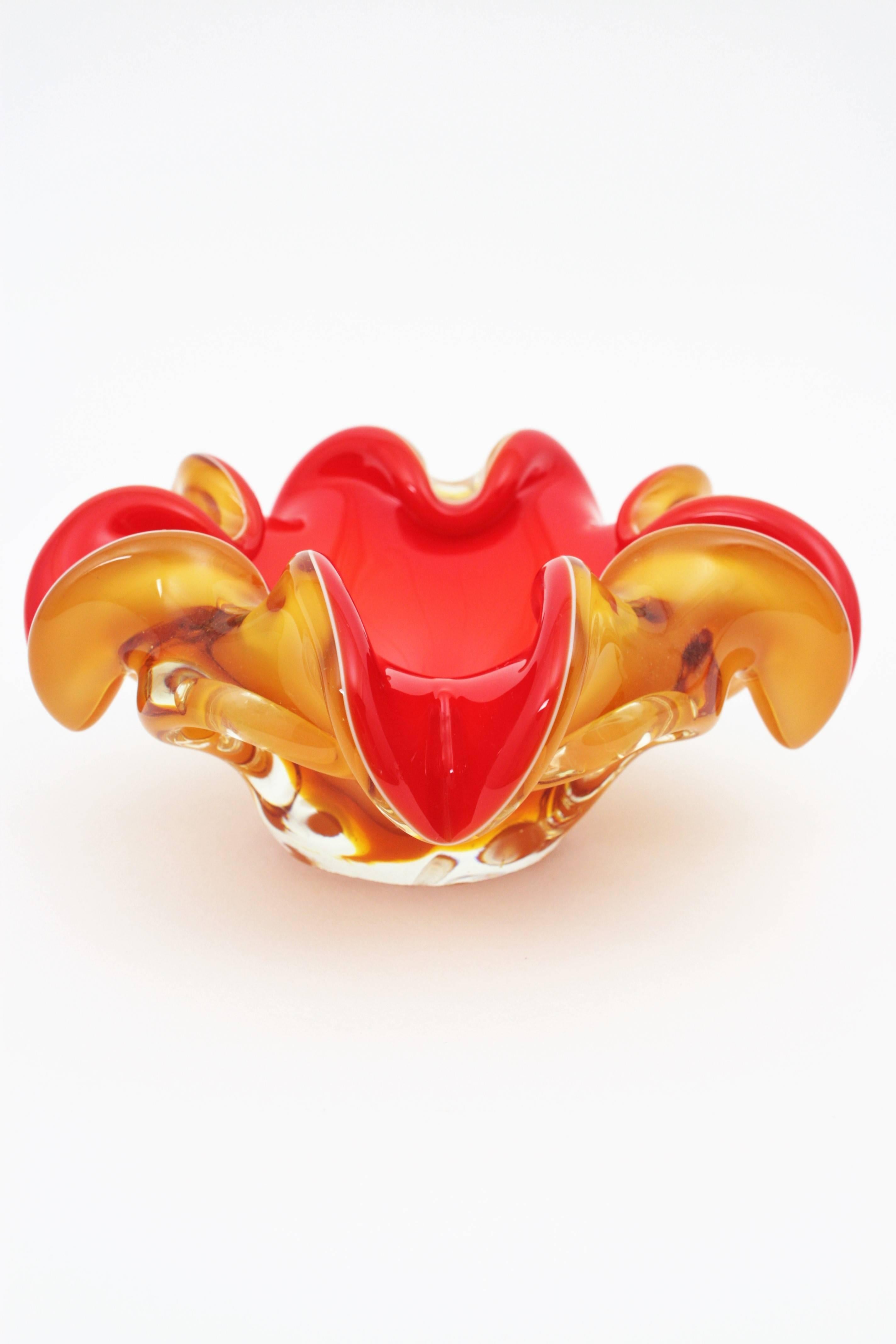 Amazing handblown Murano glass artistic flower shaped bowl or ashtray in vibrant colors. Red glass and white glass case into clear amber glass, highly decorative shapes and spectacular piece to combine with other Murano glass pieces or to use it