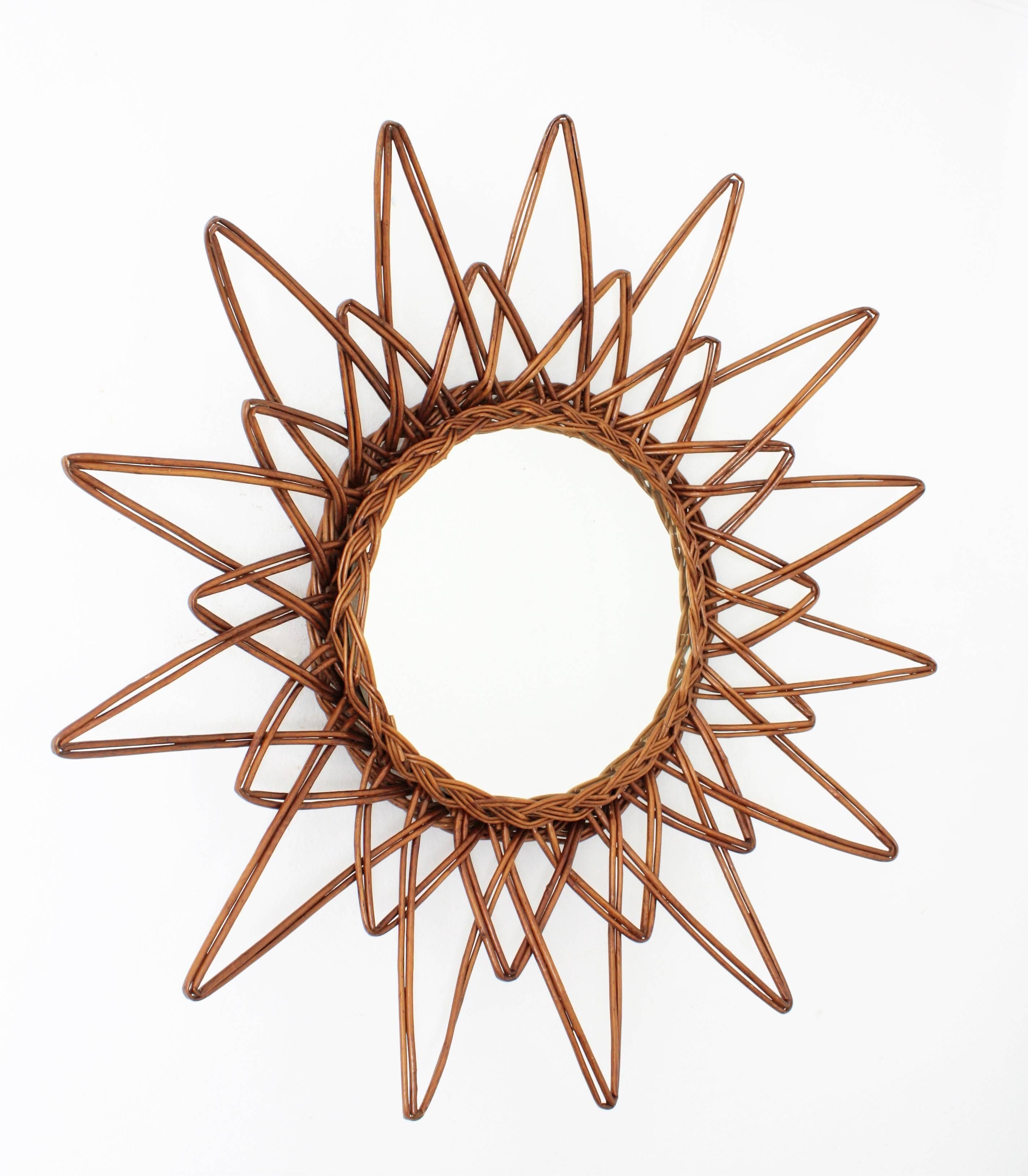 A beautiful handcrafted rattan or wicker starburst mirror. A highly decorative piece with short and long beams, star shape and beautiful color.
Spain, 1960s.

Also lovely to place with other mirrors in this manner creating a wall decoration.