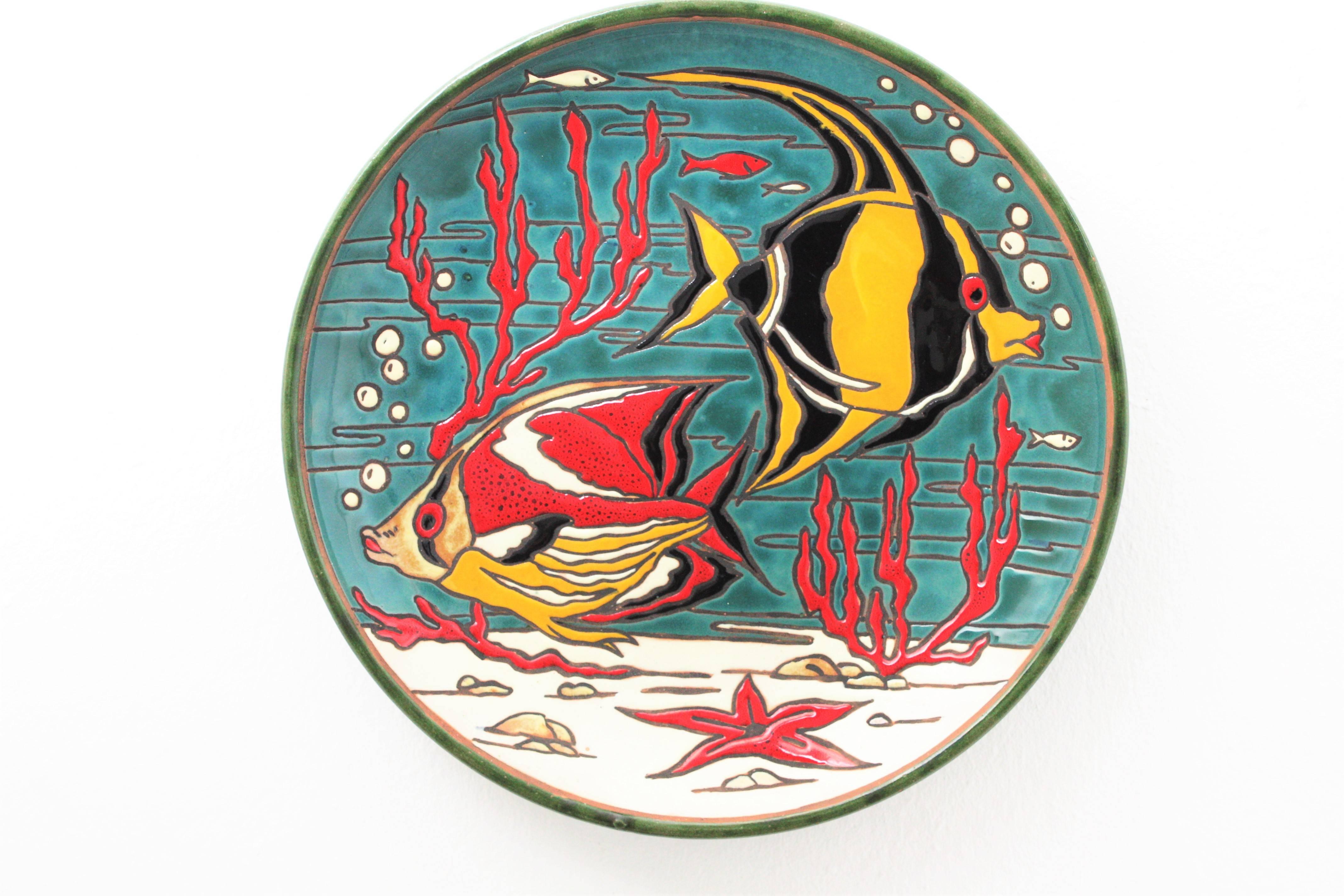 A colorful glaced ceramic large plate or platter with a sea depth landscape decoration in red, yellow, blue, black and white tones. Spain, 1950s.
The edge and the back of the platter is made in green glazed ceramic.
Lovely to hang it on the wall