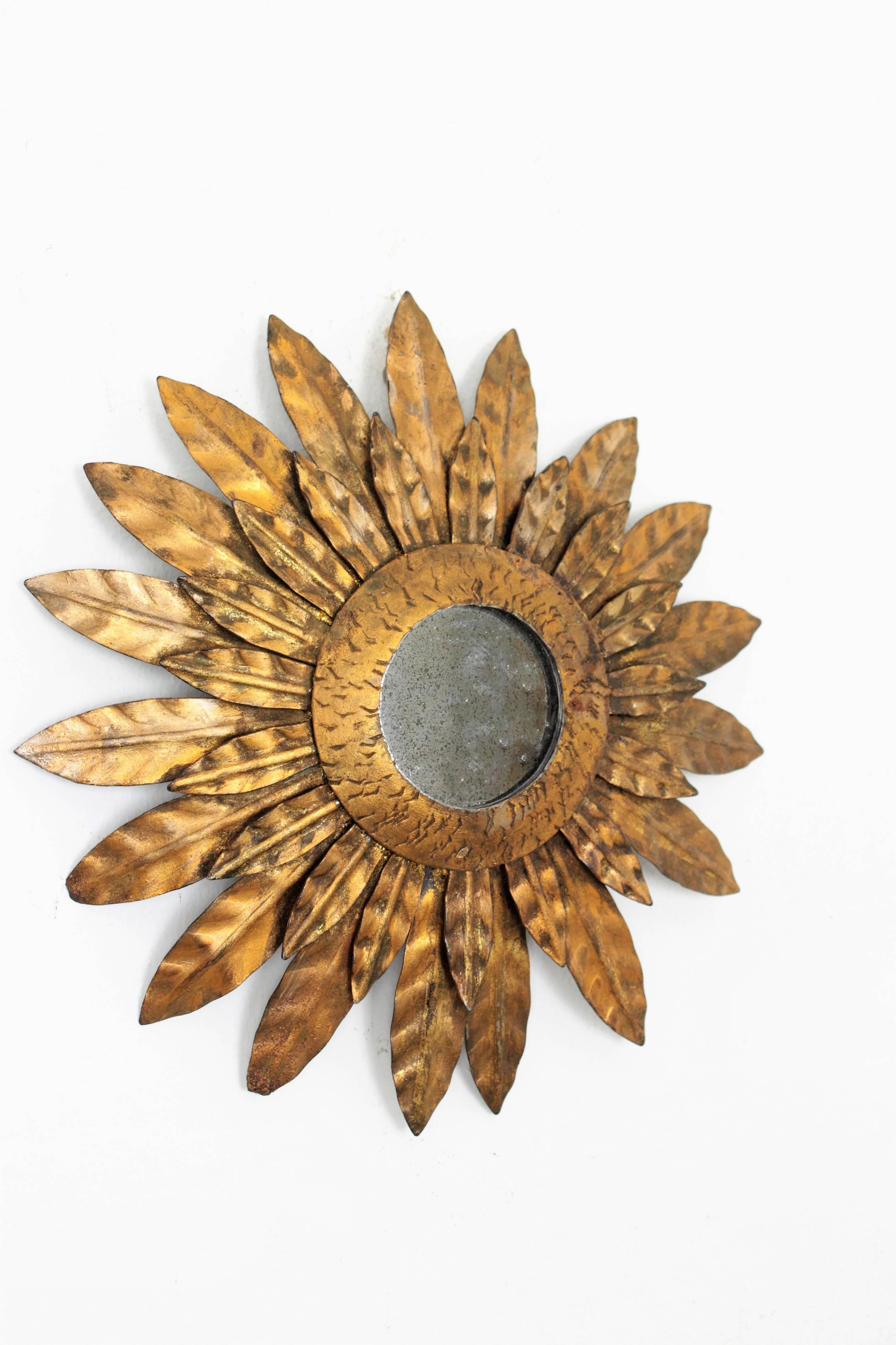 A lovely sunburst mirror of flower burst mirror made in hand-hammered iron with gold leaf finish in an unusual small size.
This piece is beautiful placed alone or hung with other mirrors in this manner creating a wall decoration with sunburst