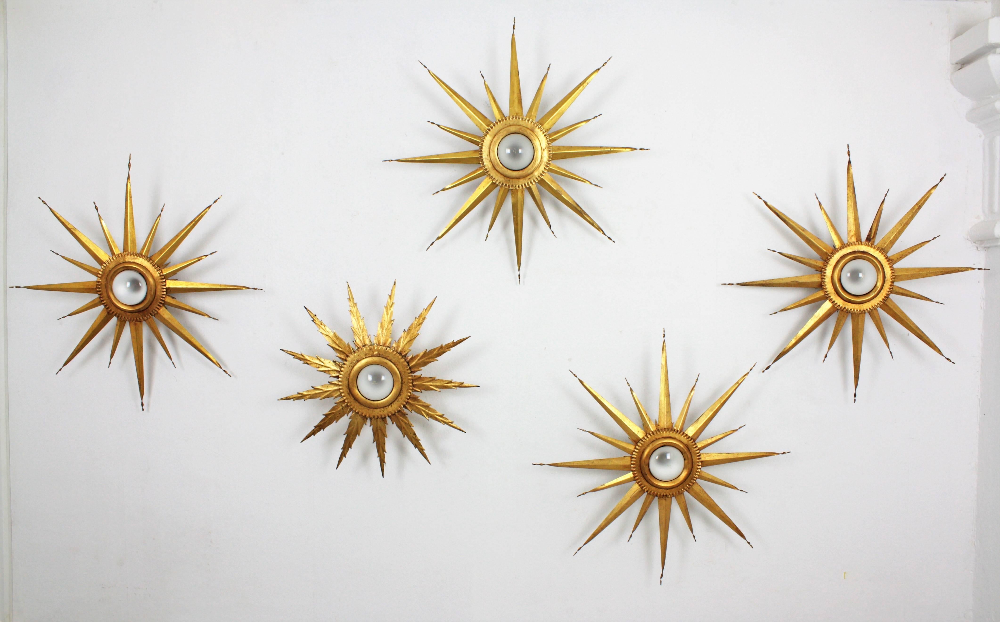 A magnificent set of twelve hand-hammered gilt iron starbursts ceiling light fixtures or wall sconces. Also spectacular to be used as a wall decoration.
These sconces have gold leaf finish and a beautiful patina,
The set is composed by nine