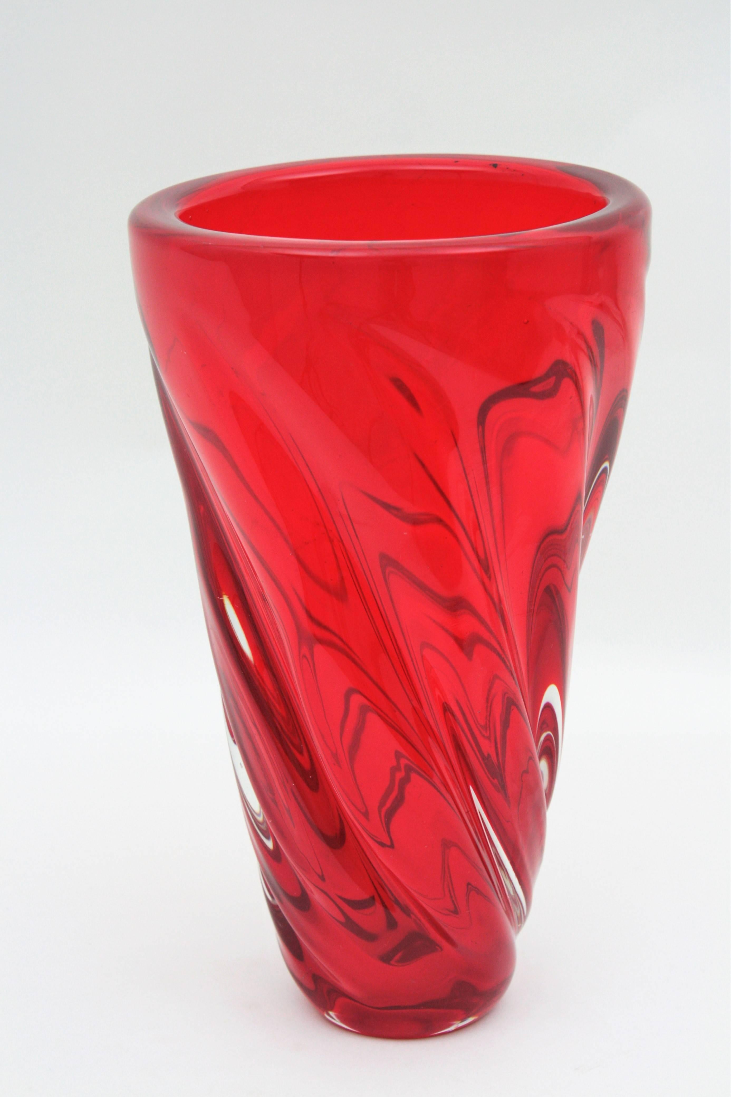 An spectacular handblown Murano art glass vase in a vibrant ruby red color and tornado twisted shape. Attributed to Archimede Seguso. Very attractive when light goes down on it.
Excellent condition. Italy, 1960s.
Use it as a flowe vase, decorative