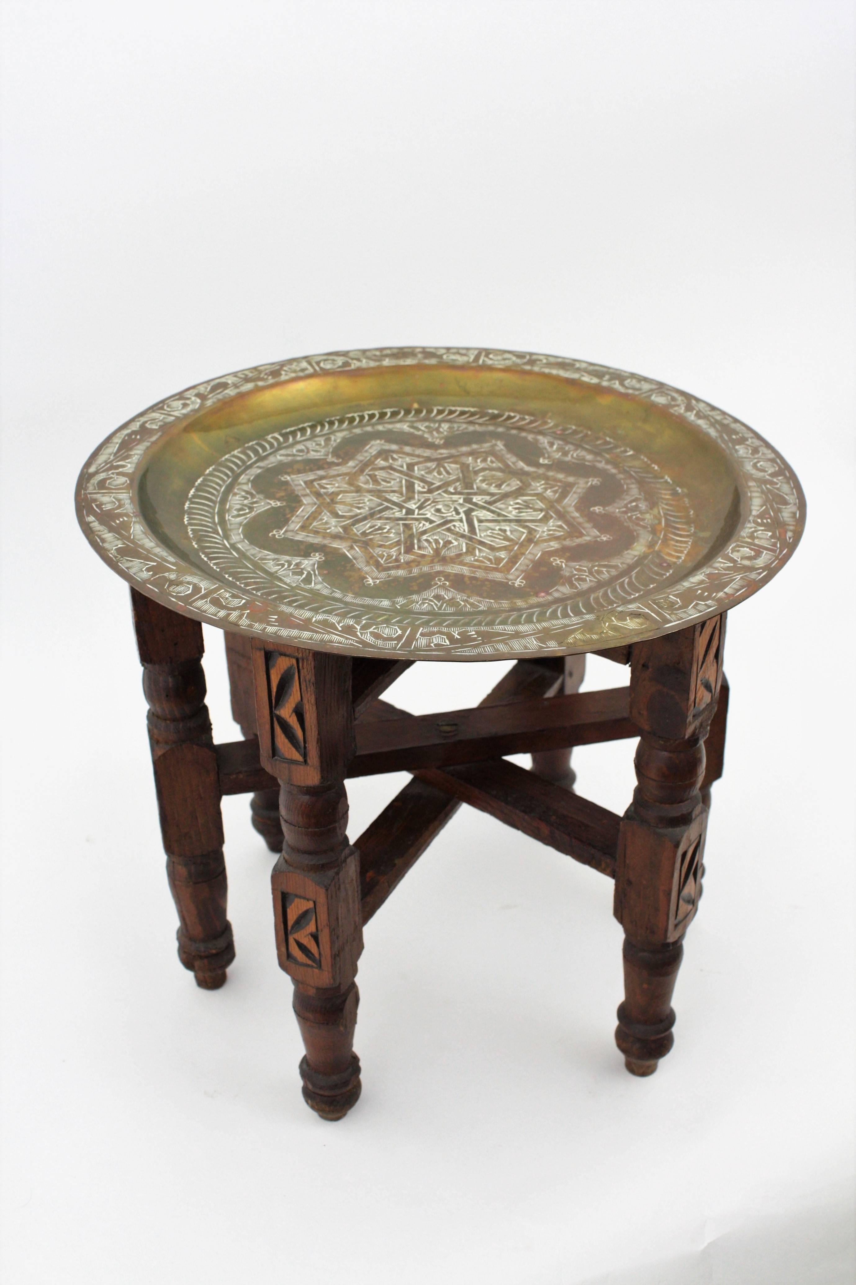 A rare miniature sized hand-hammered brass and wood folding tray table. The tray has engraved Arabic details and the wooden part has carved decorations. Useful as a pedestal and difficult to find in this size.
Morocco, 1950s.
