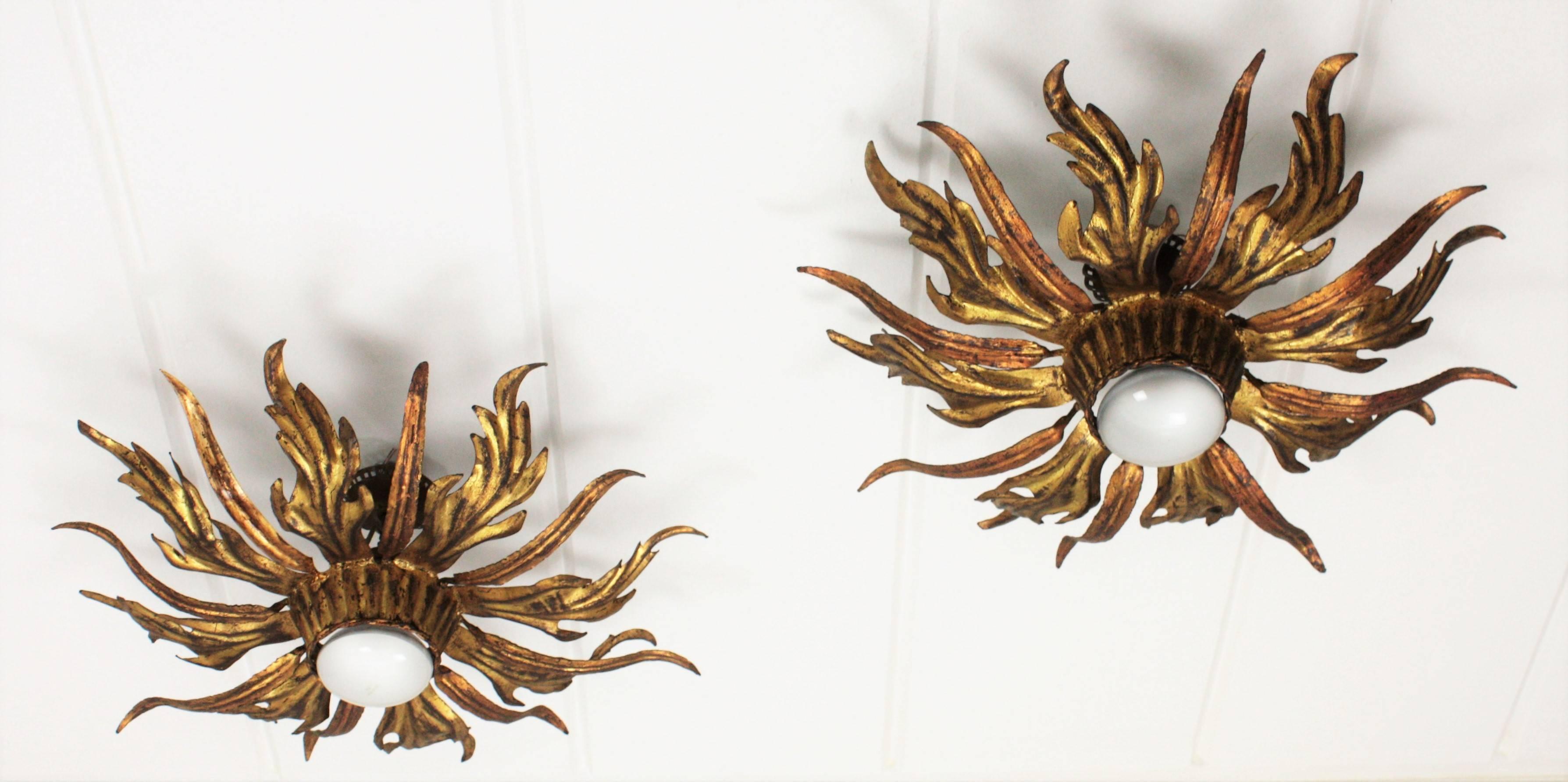 A superb pair of hand-hammered iron leafed sunburst light fixtures with leaves in two tones, coppered and gilt. Their different shaped leaves and the two colors make them highly decorative. They show their original vintage patina and they have been