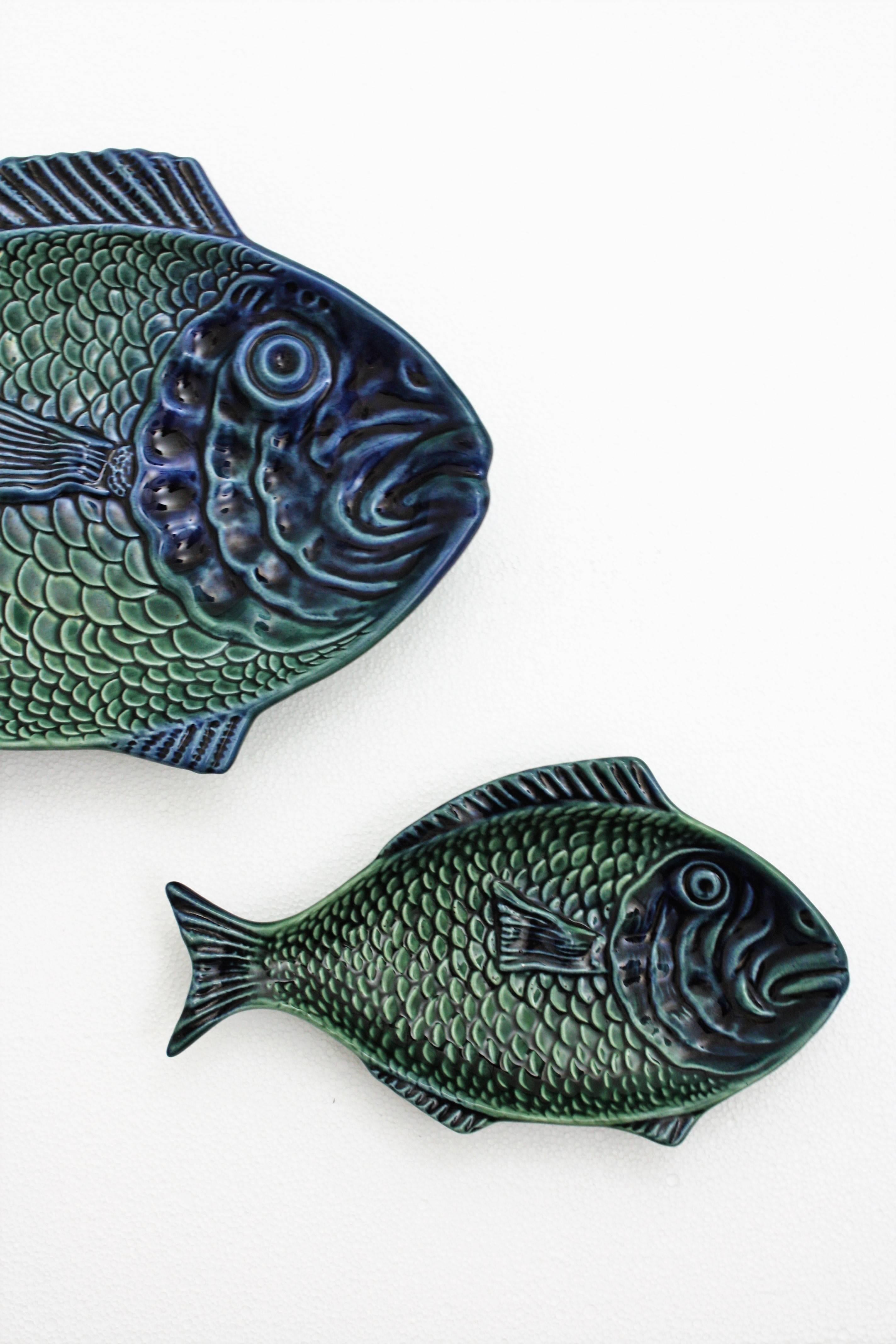 A lovely set of hand-painted glazed ceramic fish platters in green color with accents of blue in two sizes. The small one has the mark of the manufacturer at the back. Both of them are in excellent vintage condition.
Lovely to be used as serving