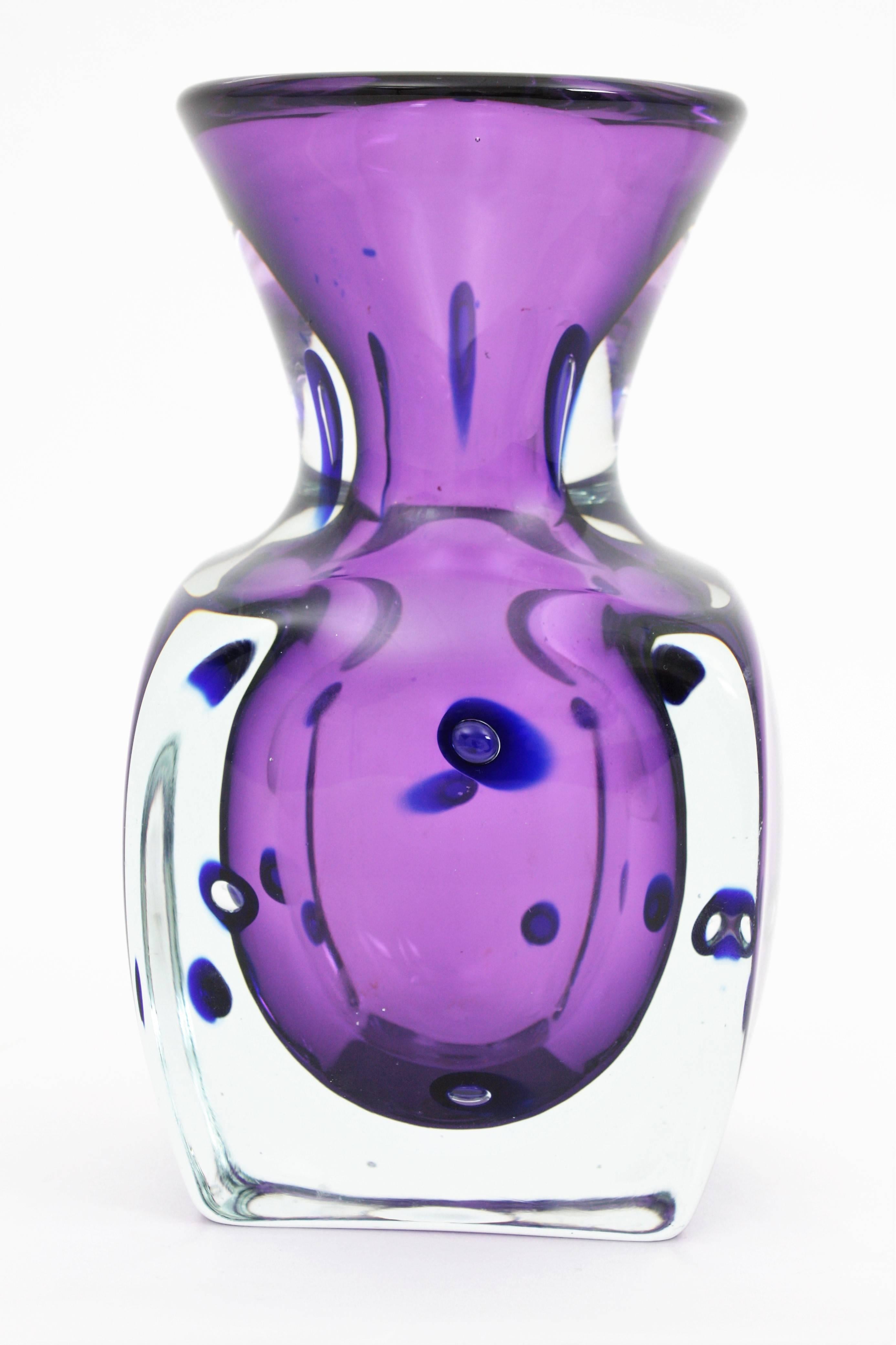 Unusual handblown Sommerso Murano glass bottle vase in clear and purple glass with blue marine large murrines and controlled bubbles attributed to Archimede Seguso. This piece is very heavy due to the base is a Sommerso block with the top part