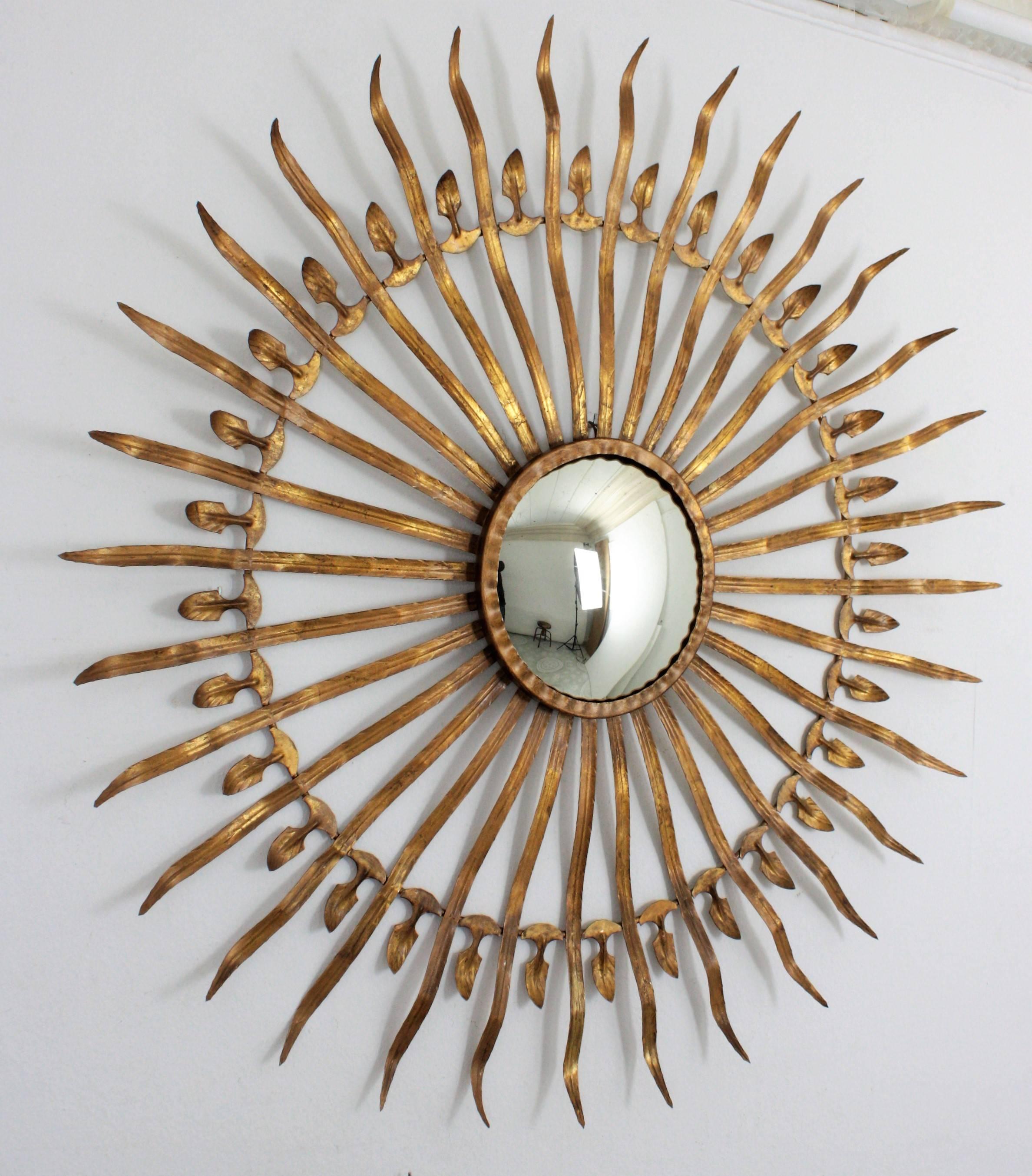 Stunning 100 cm diameter gilt iron convex sunburst mirror finished with gold leaf. This magnificent sunburst wall mirror can work also as a wall mounted sculpture. Glass diameter: 22 cm.
Spain, 1950s. Ferrocolor stamped mark on the back.


 