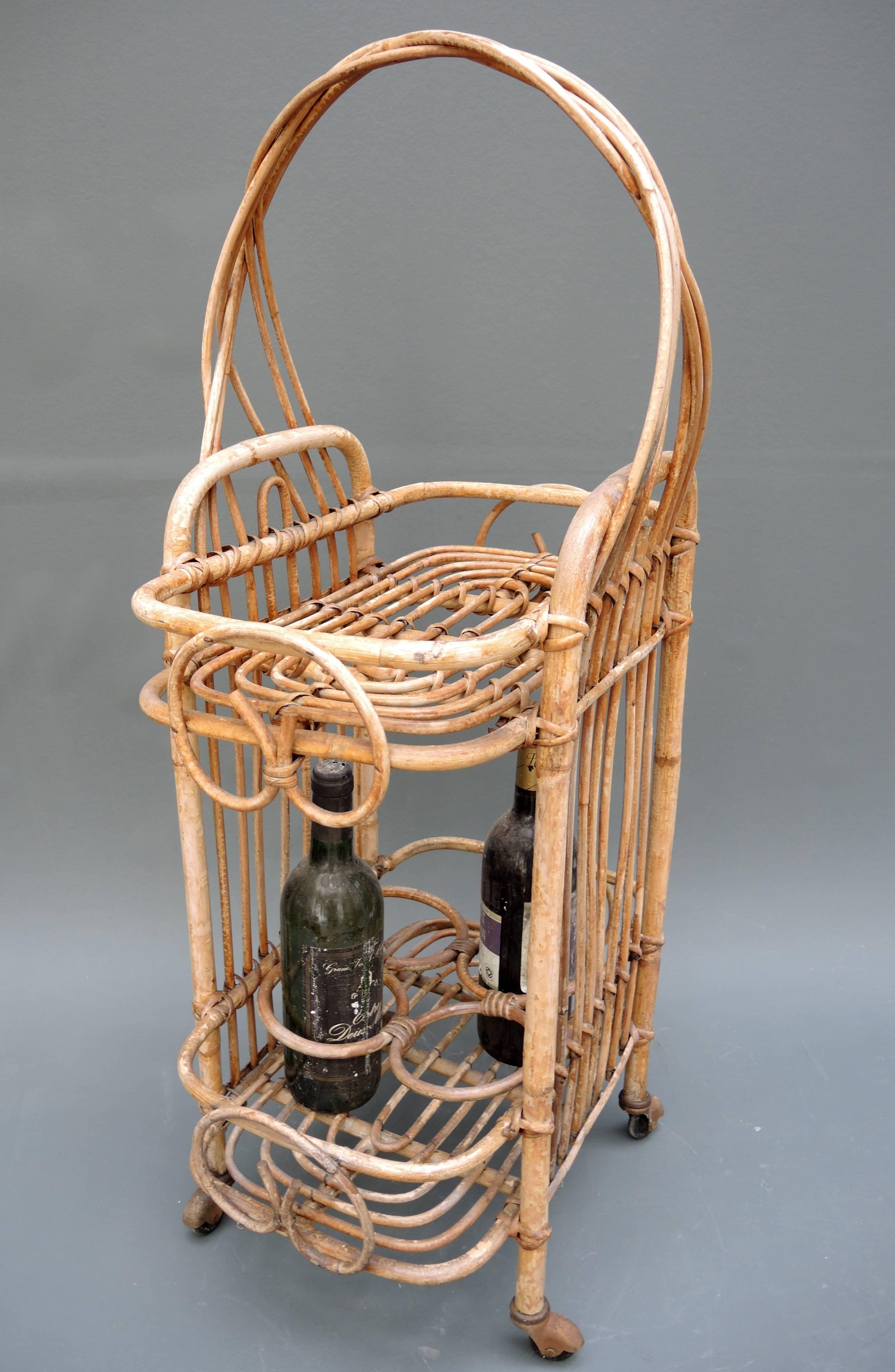 Unique small French bamboo bar cart. The perfect size for serving summer aperitifs and wine! Very good sturdy condition with the original wheels and an elegant braided handle. The wine bottles pictured are not included but shown for size reference.