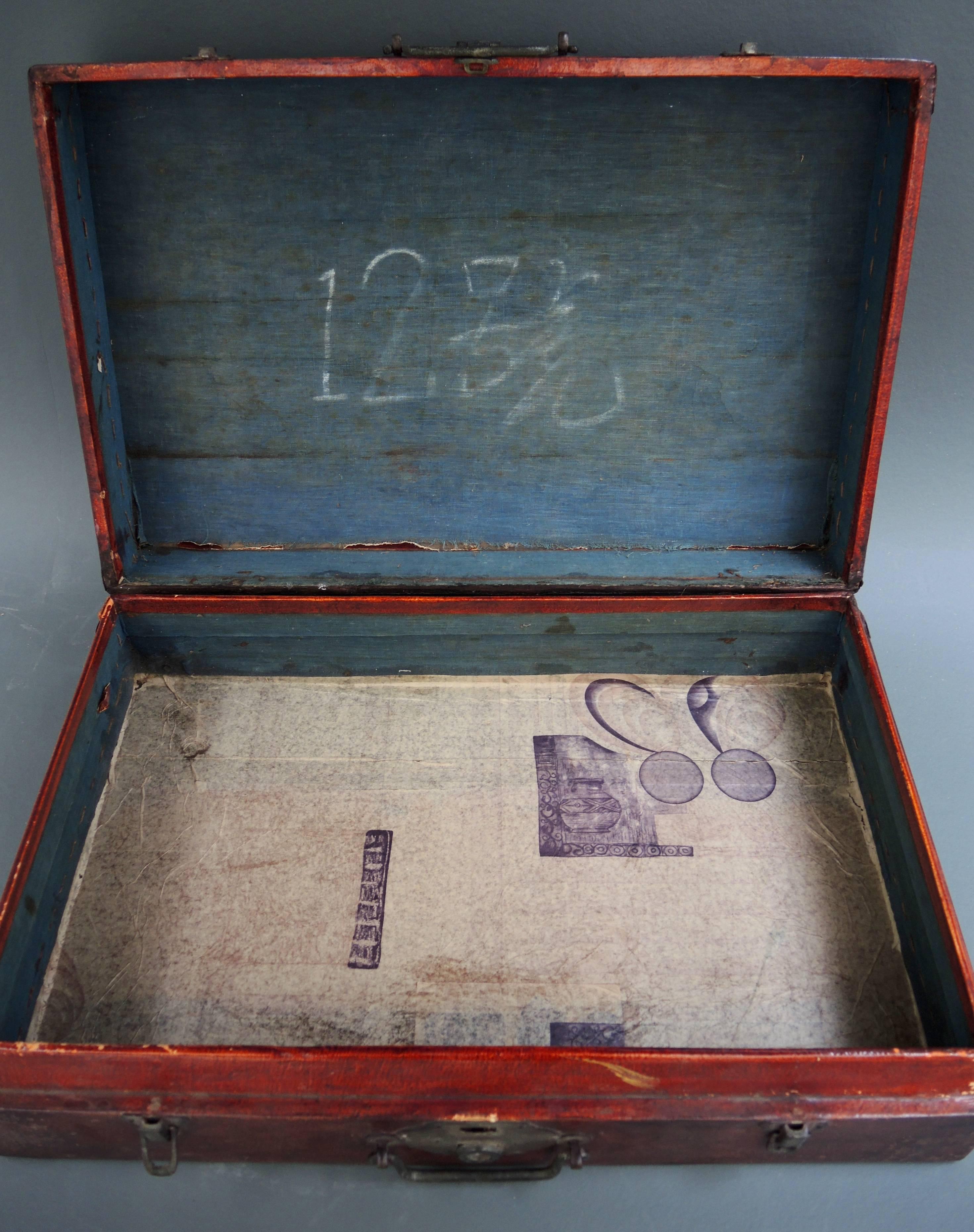 A most elegant Chinese suitcase made of wood and covered in goatskin leather. The interior is lined in hand woven indigo cotton and paper and the handles and lock are hand cast bronze.