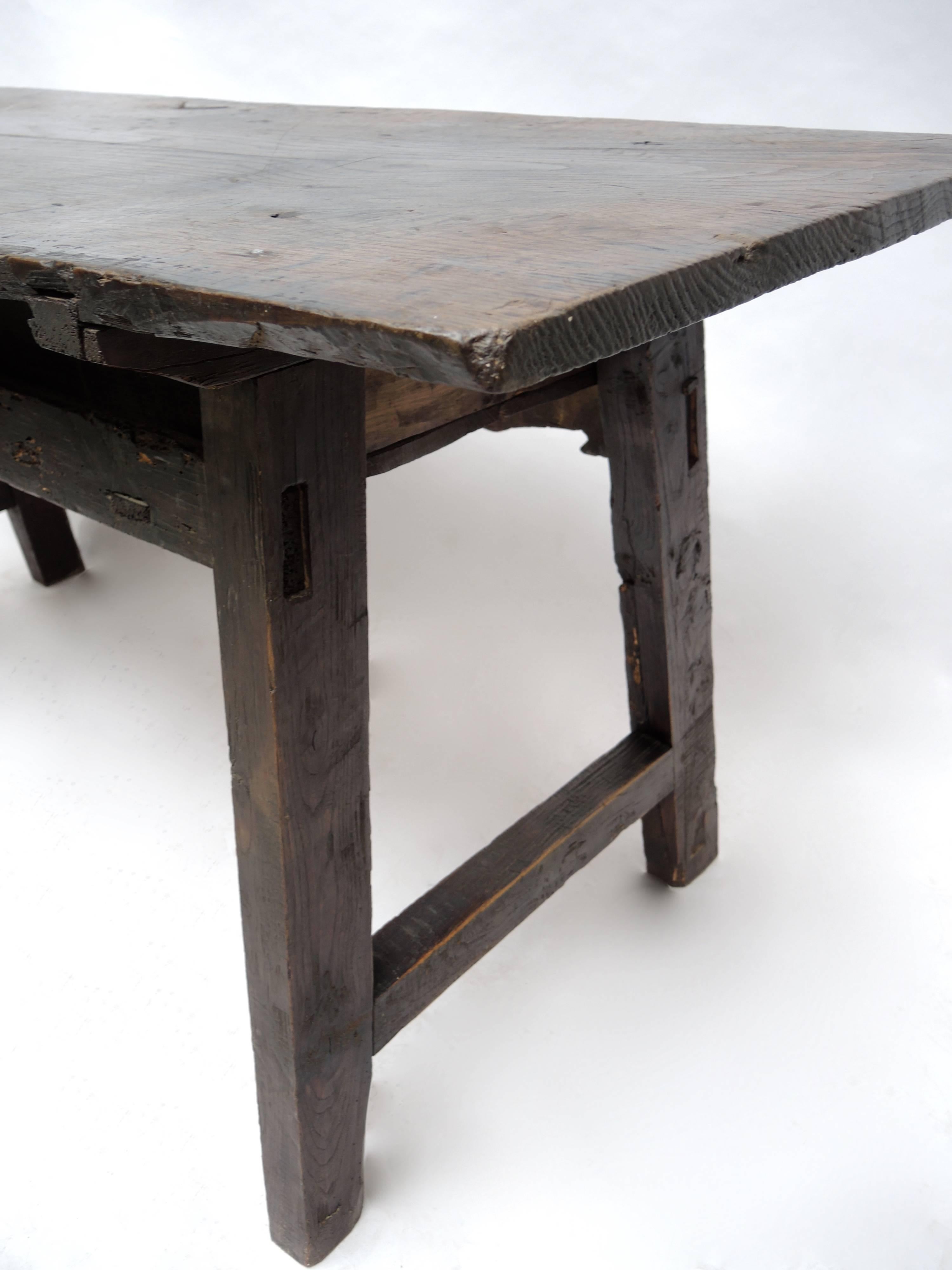 This beautiful Spanish Baroque table has an impressive and rare one board chestnut top. The table is made of solid chestnut and boast a very solid construction and smooth worn patina . The center drawer retains the original hand-wrought hardware,