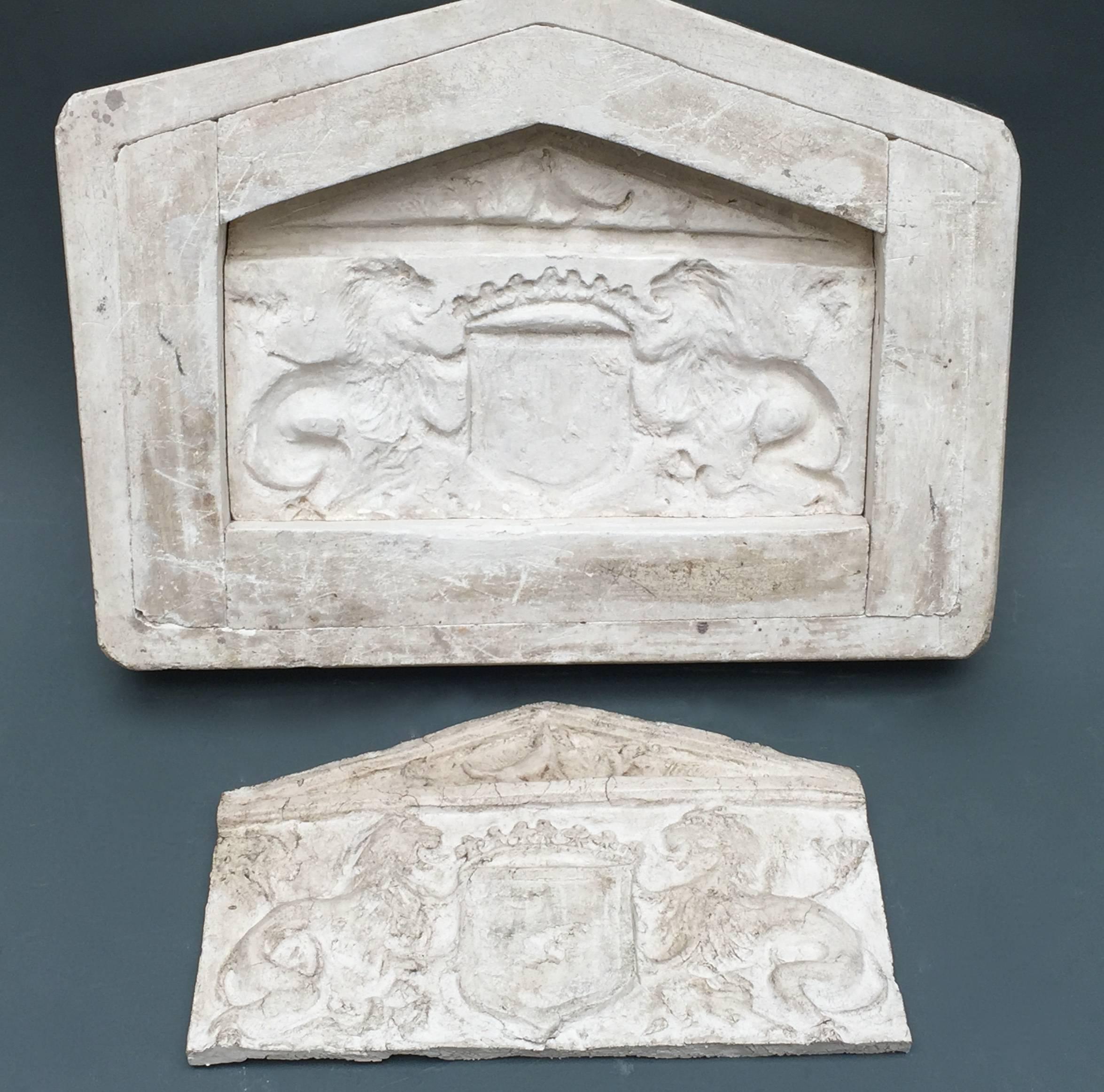 A French five part plaster mold to cast an armorial pediment design. We have pressed clay into the mold to show the result of the finished 