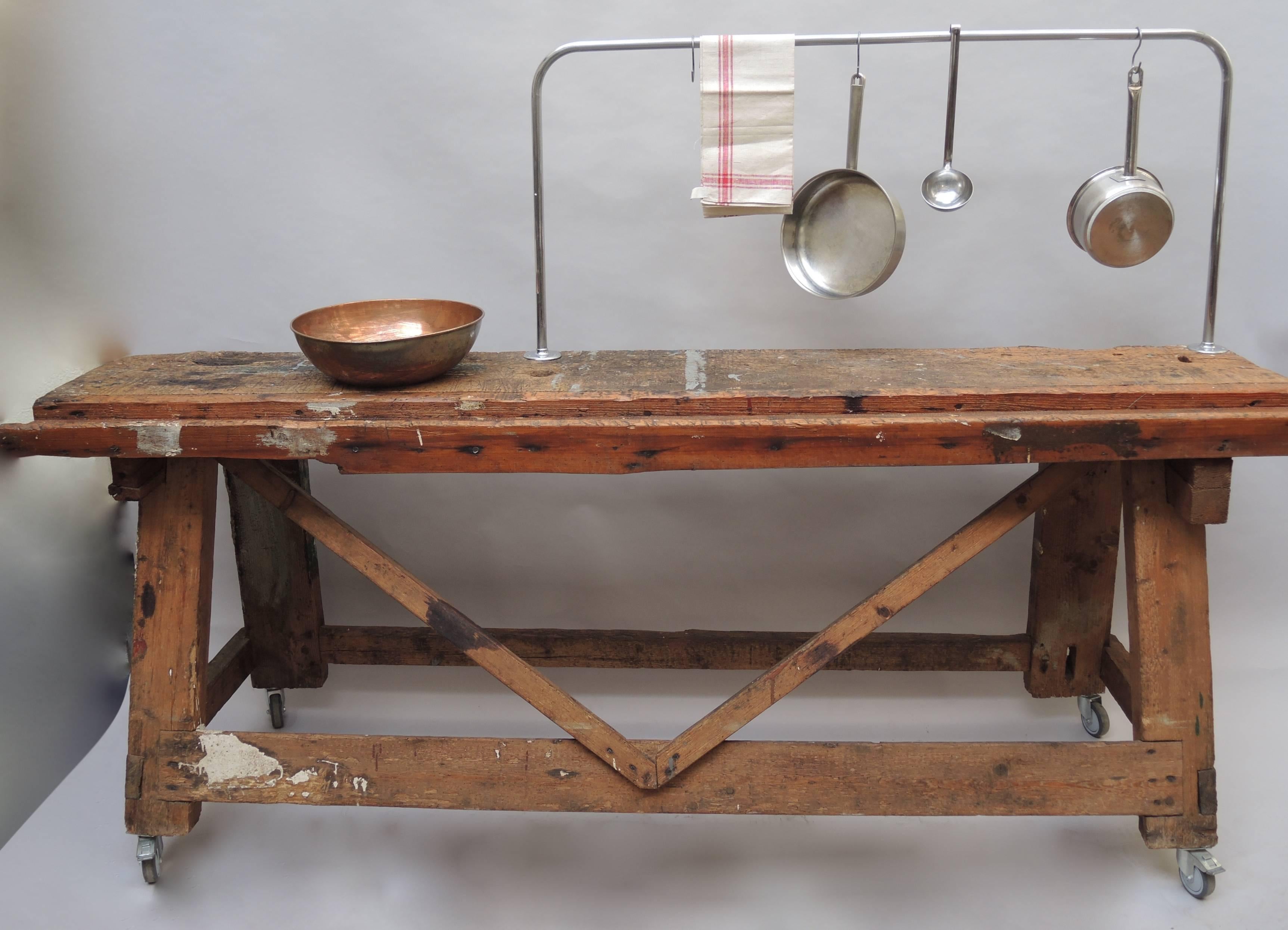 A great looking naturally worn work bench from a Belgian cabinet makers workshop. Old splatters of paint and saw cuts add to the perfect mellow patina of the honey colored oak work surface. There is a chrome bar that would be great to use to hang