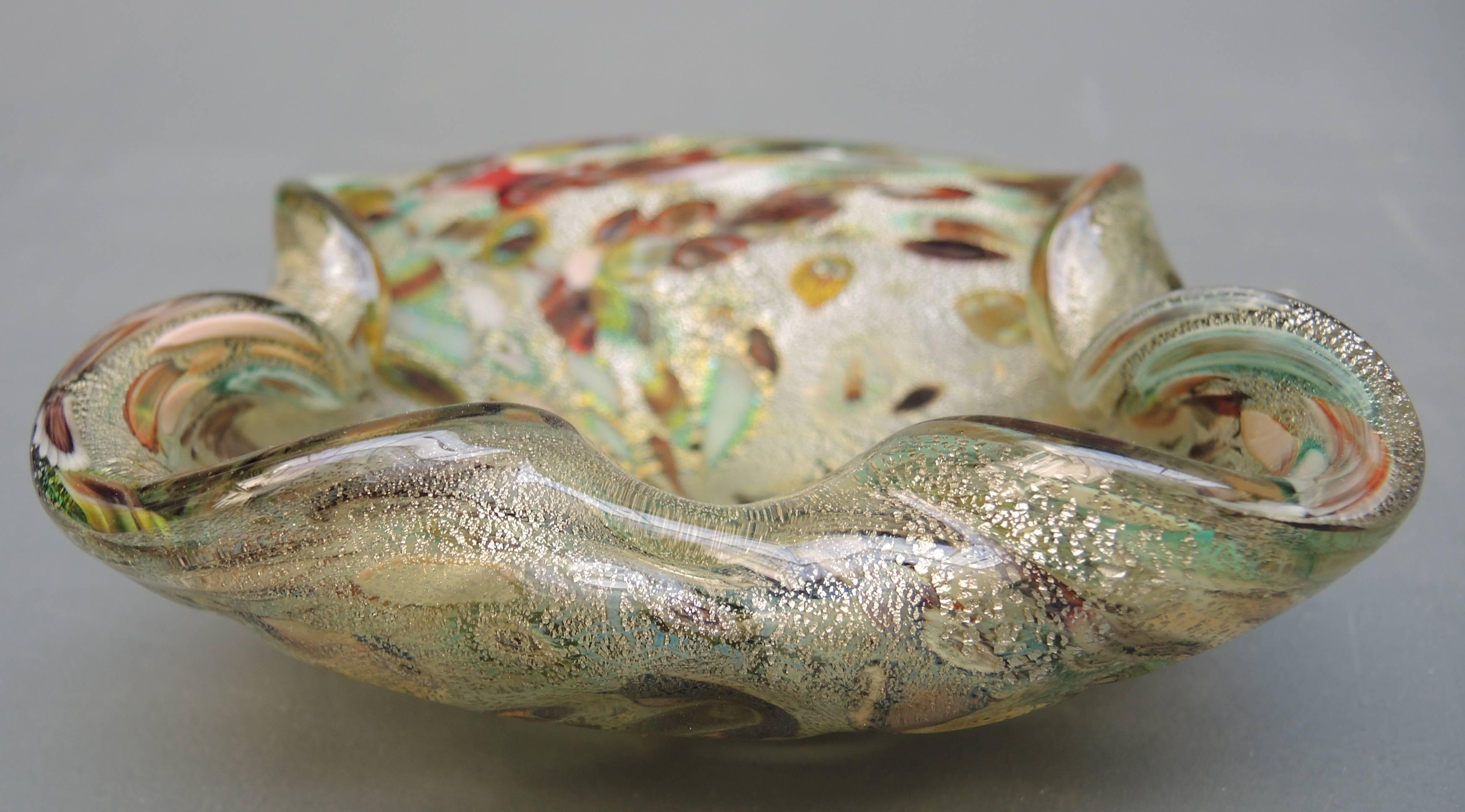 Vintage handblown Murano art glass bowl with Murrine decorations and gold leaf flecks attributed to the designer Aldo Nason and manufactured by Arte Vetraria Muranese, AVEM in the early 1960s.
Expert layering of clear glass, murrine and gold flecks