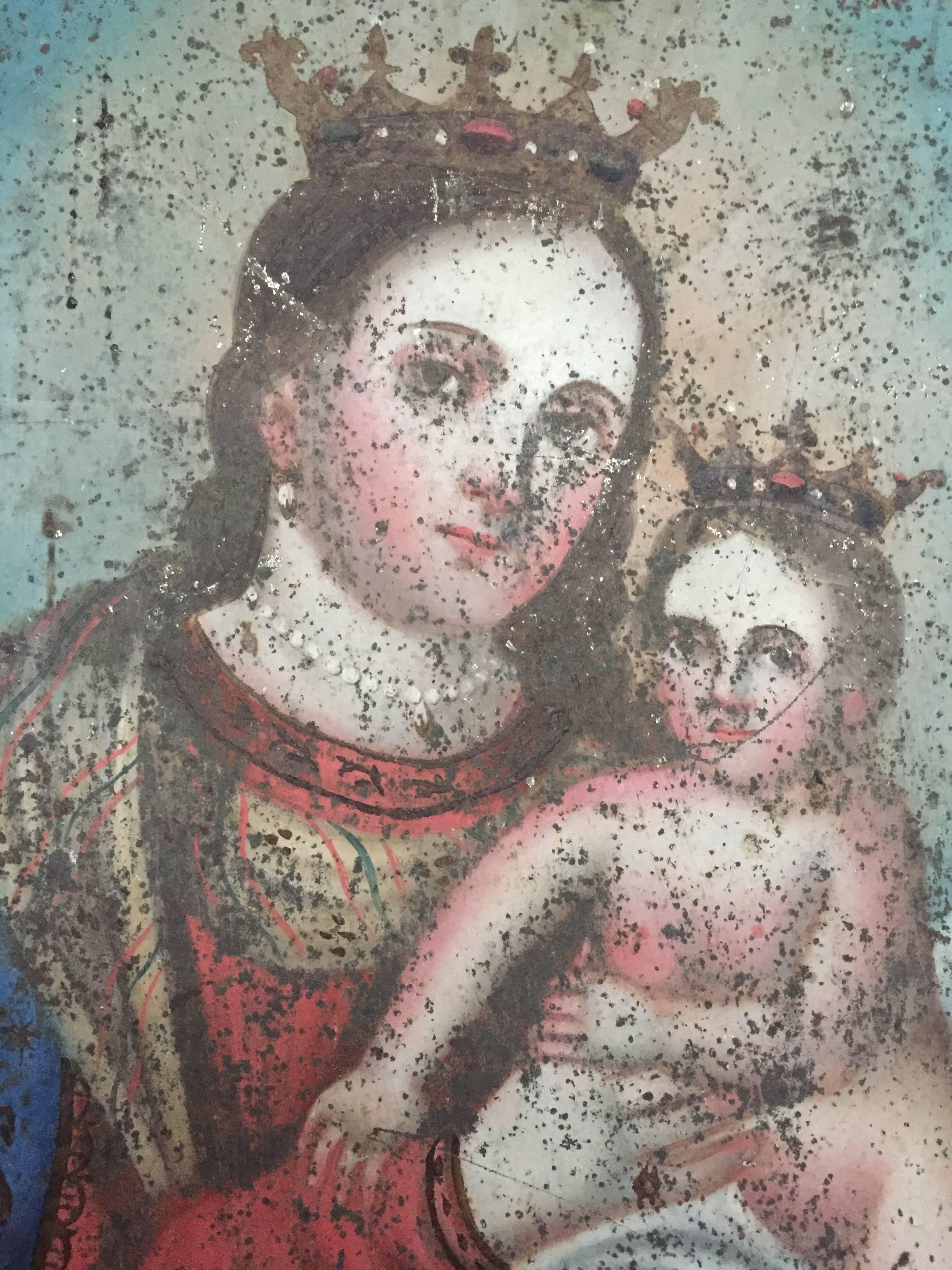 A very fine Spanish retablo painting on tin of the Maria and child. Elegant angular faces indicative of early 19th century religious painting.