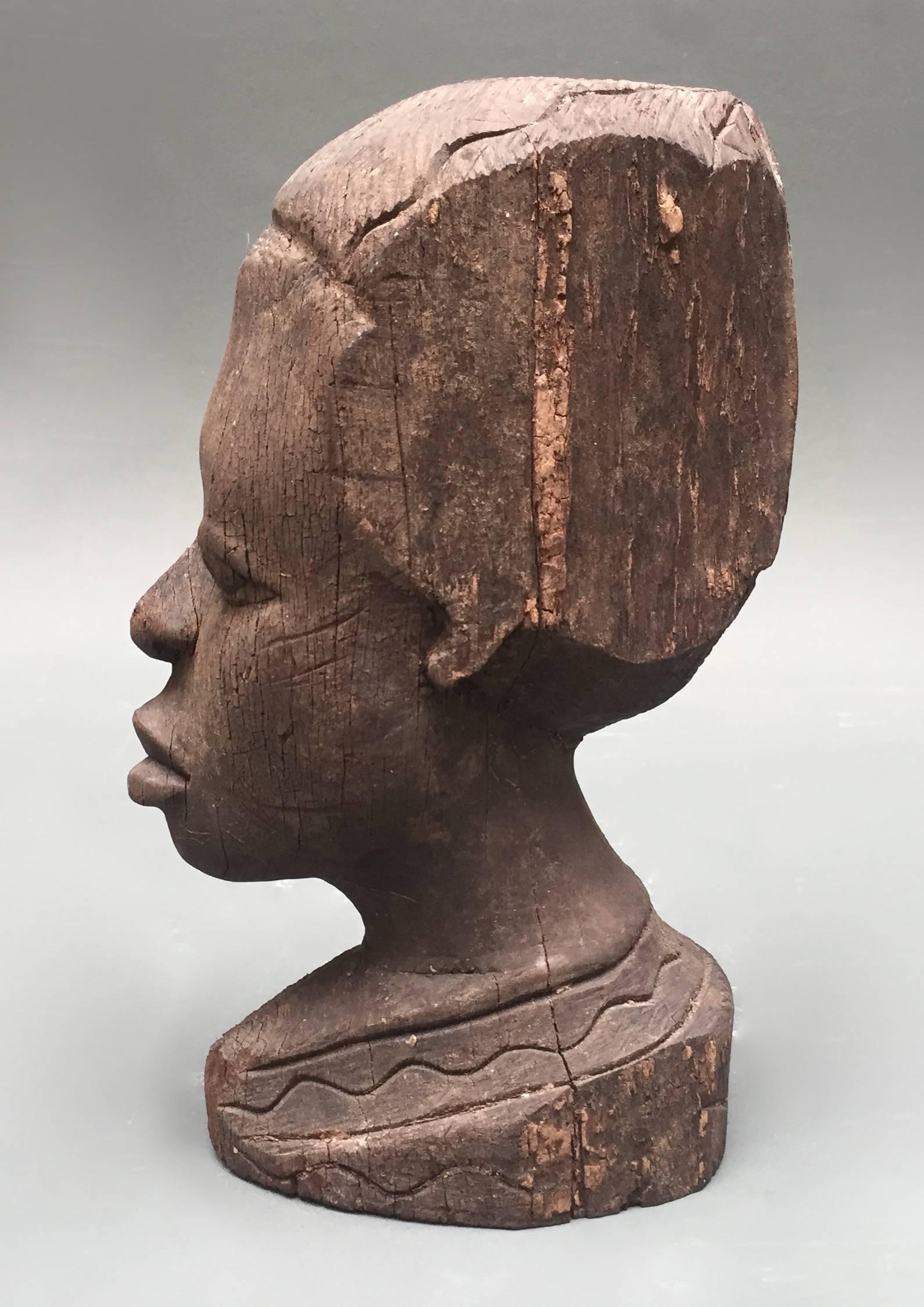 This bust comes from my own collection of vintage and antique heads. The primitive but skilled carving and the contours and cracks of the wood organically complement each other .The head is carved from a solid piece of very heavy wood and has a flat