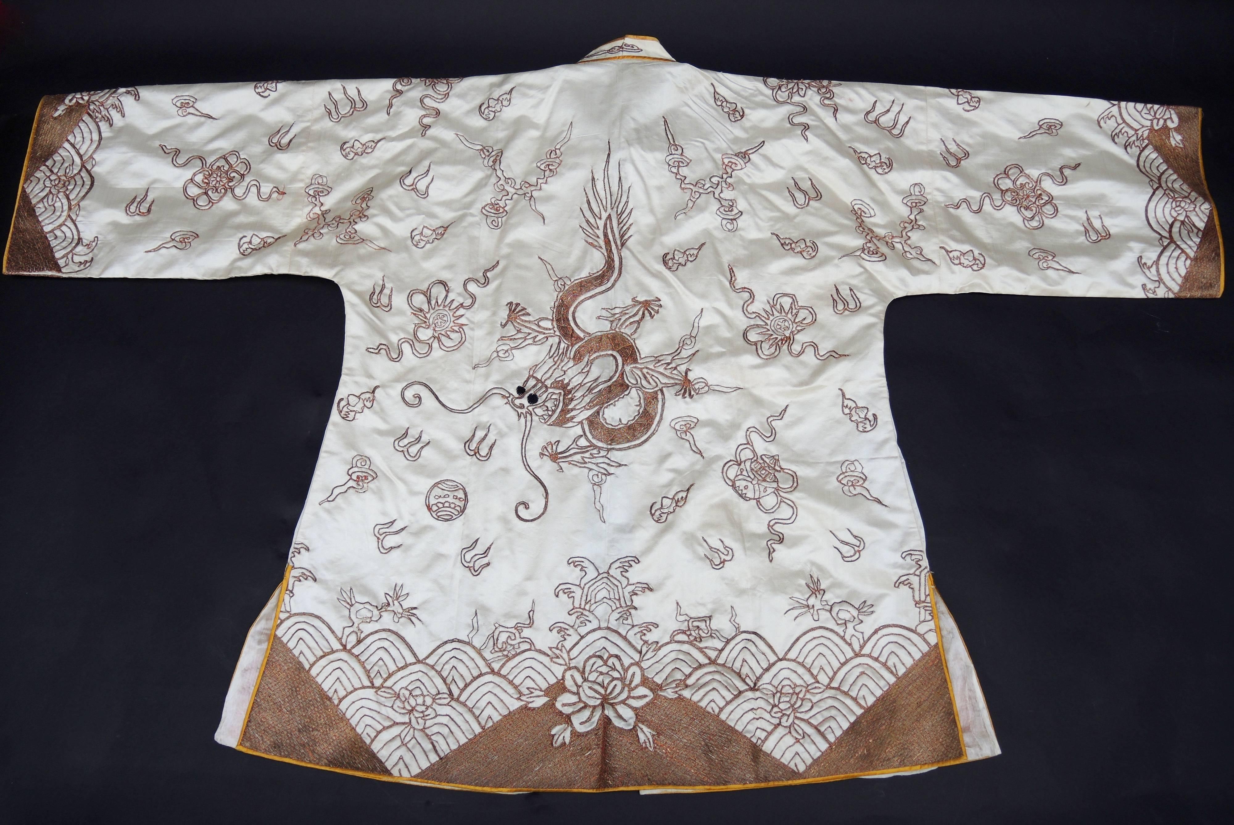 This 1940's Chinese jacket is in amazing condition and is heavily adorned with jewel like gold hand embroidery . The couching embroidery technique is accomplished by hand sewing thin pieces of paper that have been tightly wrapped in gold metal foil
