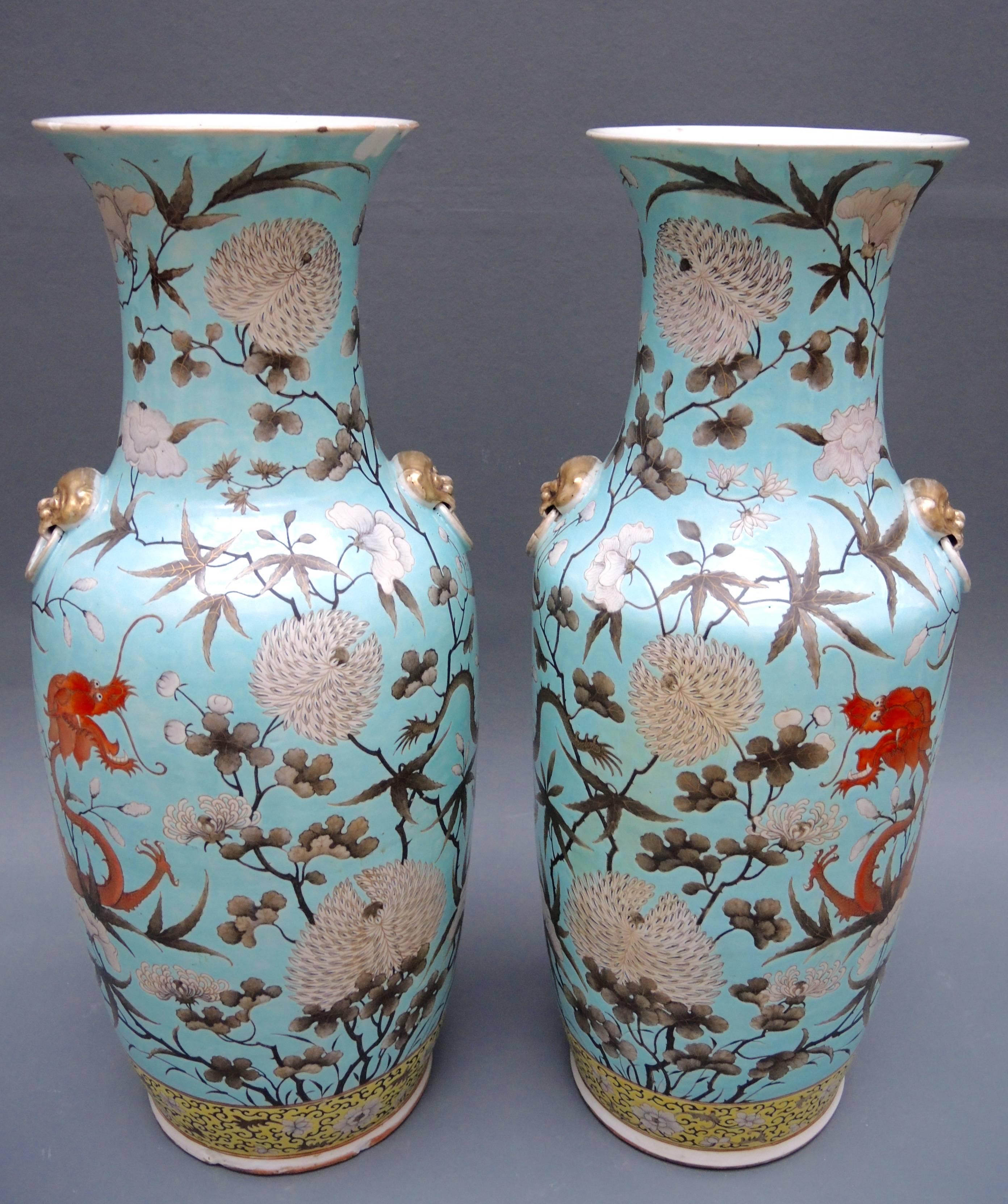 A striking pair of Chinese baluster vases in the most unusual turquoise blue color. Wild orange and brown dragons dance among vines and chrysanthemum blooms. One vase has chips to the base and top lip.
 