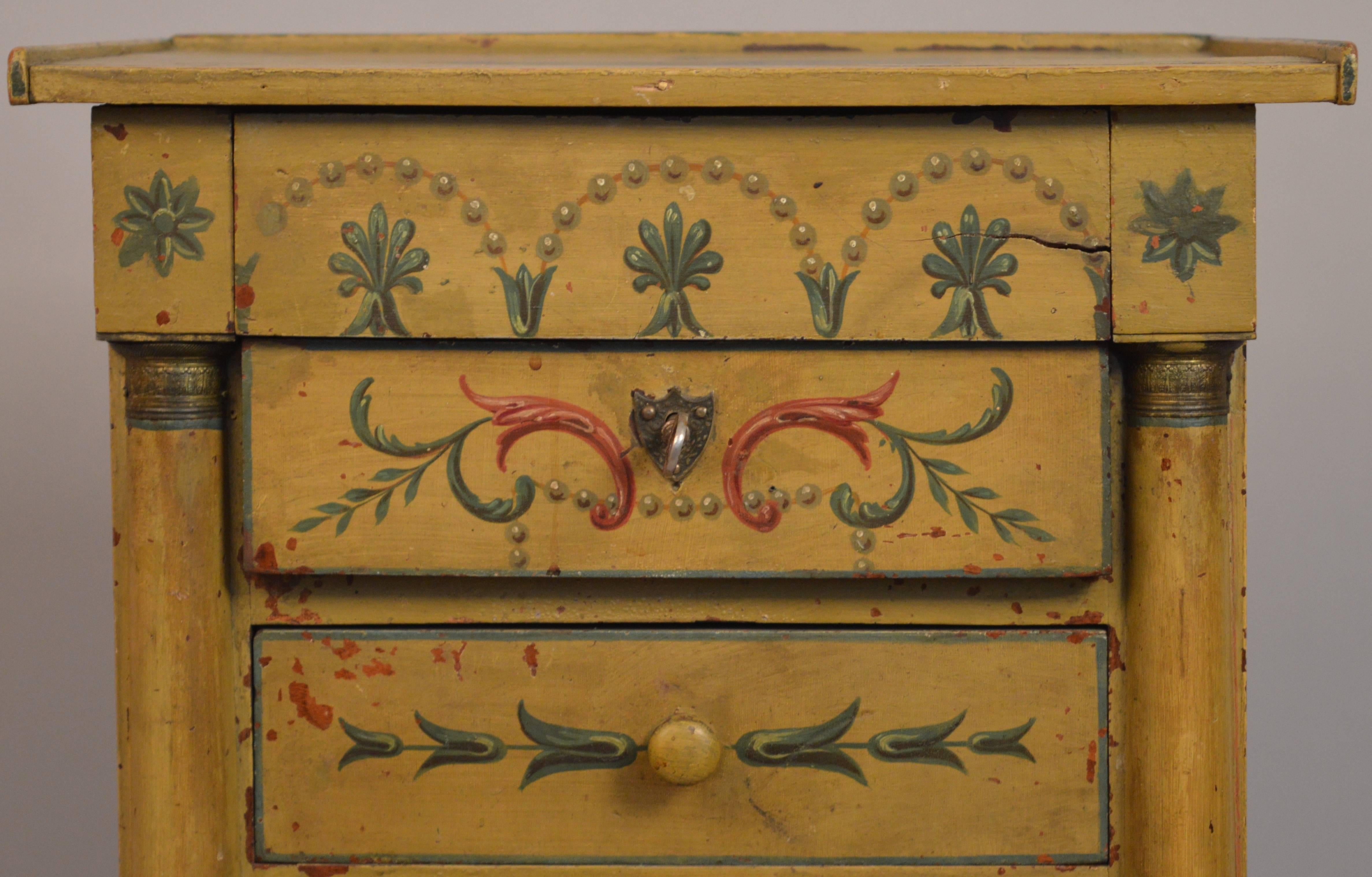 19th Century Empire yellow Austrian painted side table with three-drawers. The classical scenes of angels and trompe l'oeil chains of pearls are superbly painted in the classical color scheme of gold, green, blue and hints of orange.
