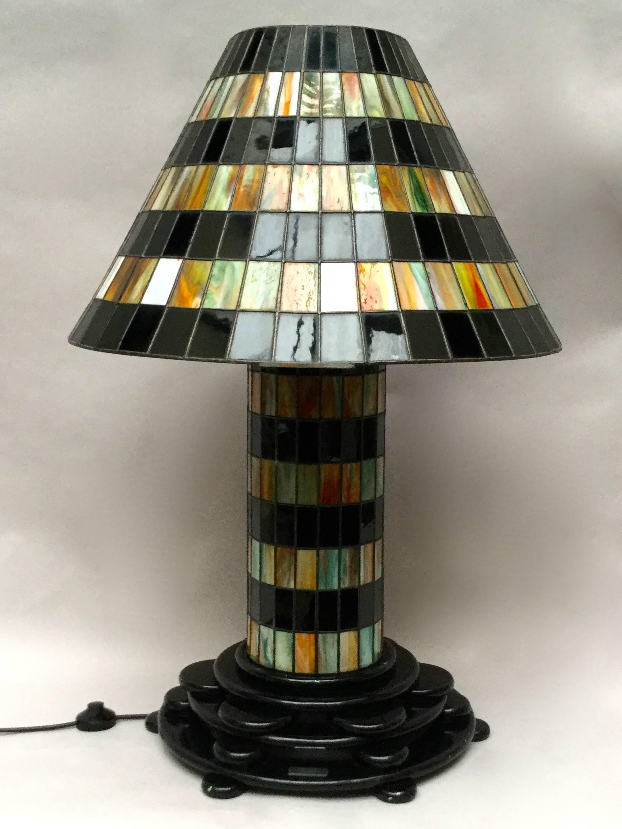 A rare large Belgian Art Deco lamp. The elegant tiered wood foot bears the weight of the leaded glass body and shade, as well as adding a sculptural masculine quality to the design. The base is mounted with a metal plaque that reads 