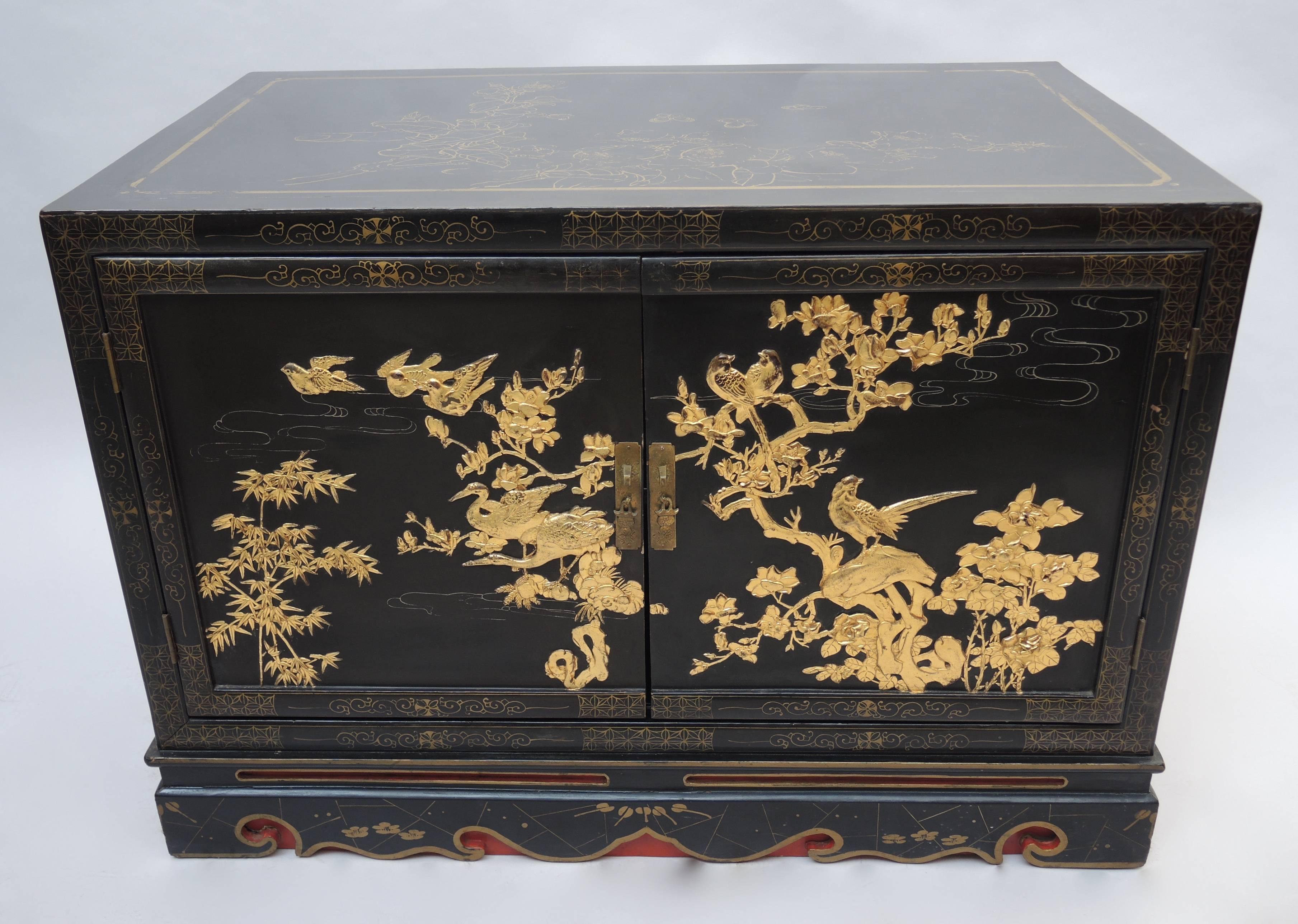 Black and gold lacquered Chinese cabinet with carved Jiang xi panels made for export to the thriving European interior market of the 1930s hungry for Asian influenced exotic designs.
The side and front panels have beautifully detailed carved