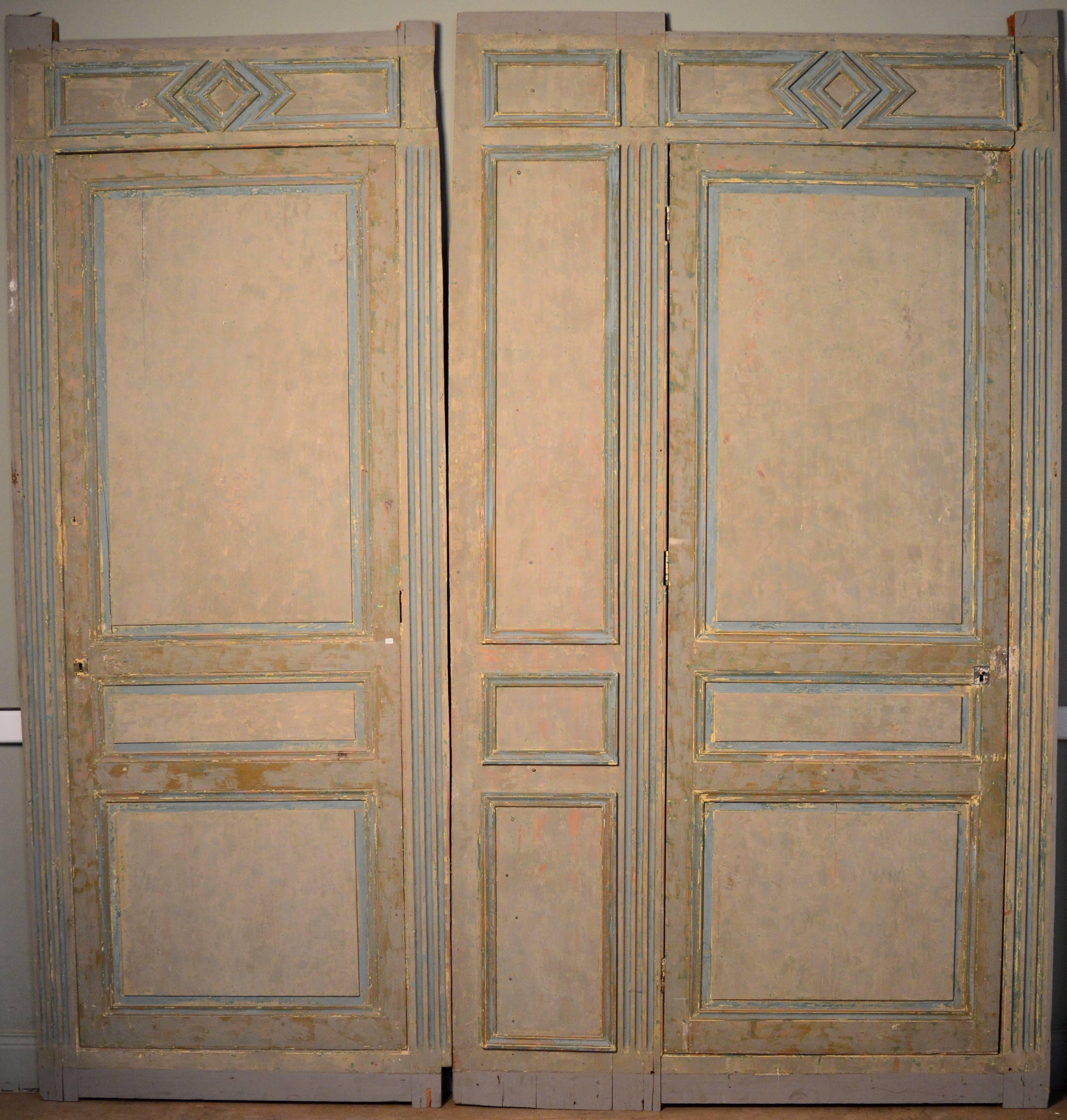 Mid-19th century French paneling with two doors. Scraped to reveal the wonderful old paint colors. 
***The paneling can be configured with the doors side by side or with the narrow panel in the center.
The doors measure 80.50 W x 215 H cm.