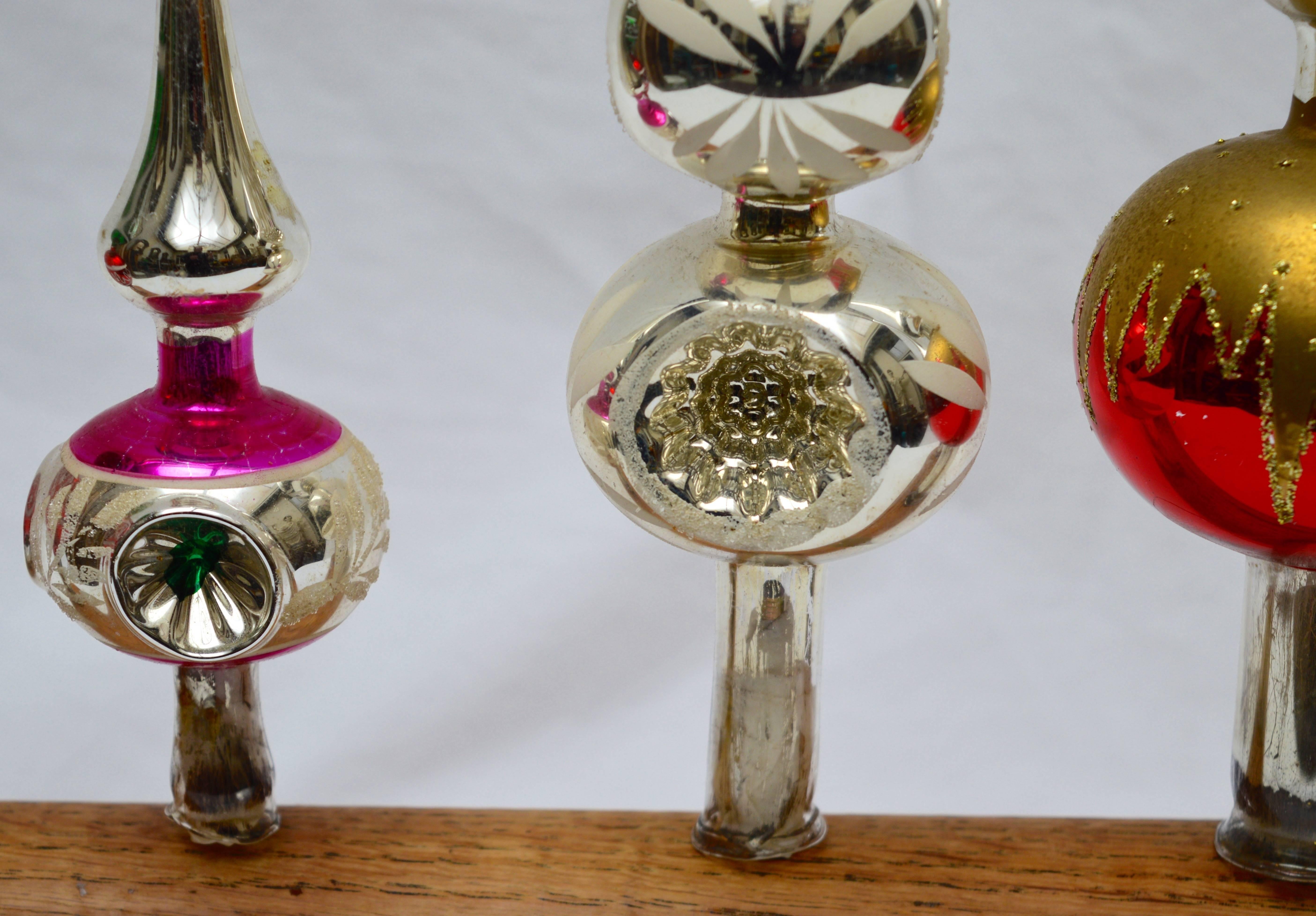 A collection of five circa 1940's and 1950's German  mercury glass Christmas tree topper ornaments in Excellent condition.
We have had a stand made from an antique wood fragment for an elegant year round display.
height shown reflects the highest