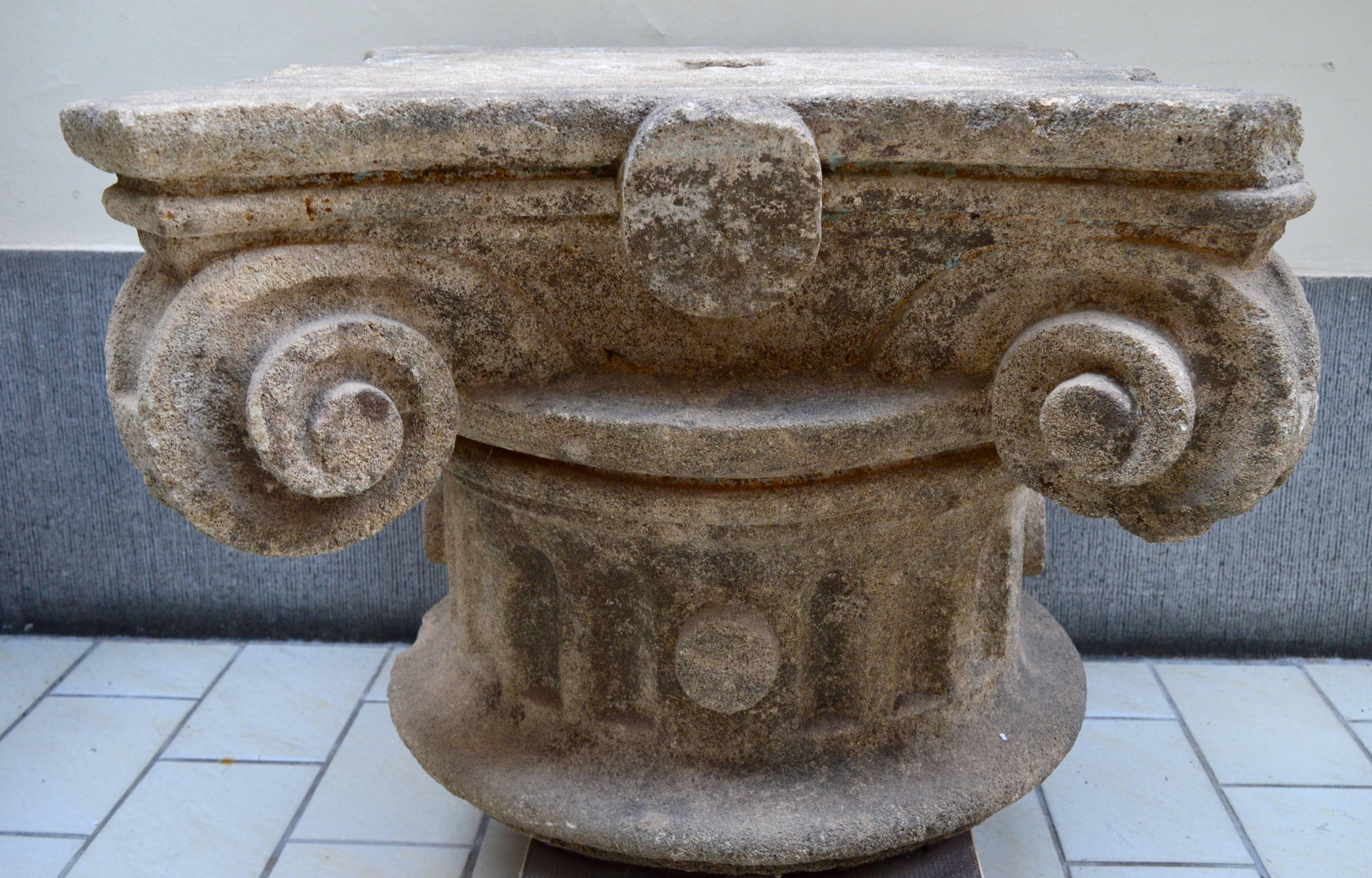  Robust carved French fossiliferous limestone capitals. Wide curled corners with central oval cartouches on all sides. They could be used alone as decorative elements or as a salon table or side tables with or without a glass top. A rare and elegant
