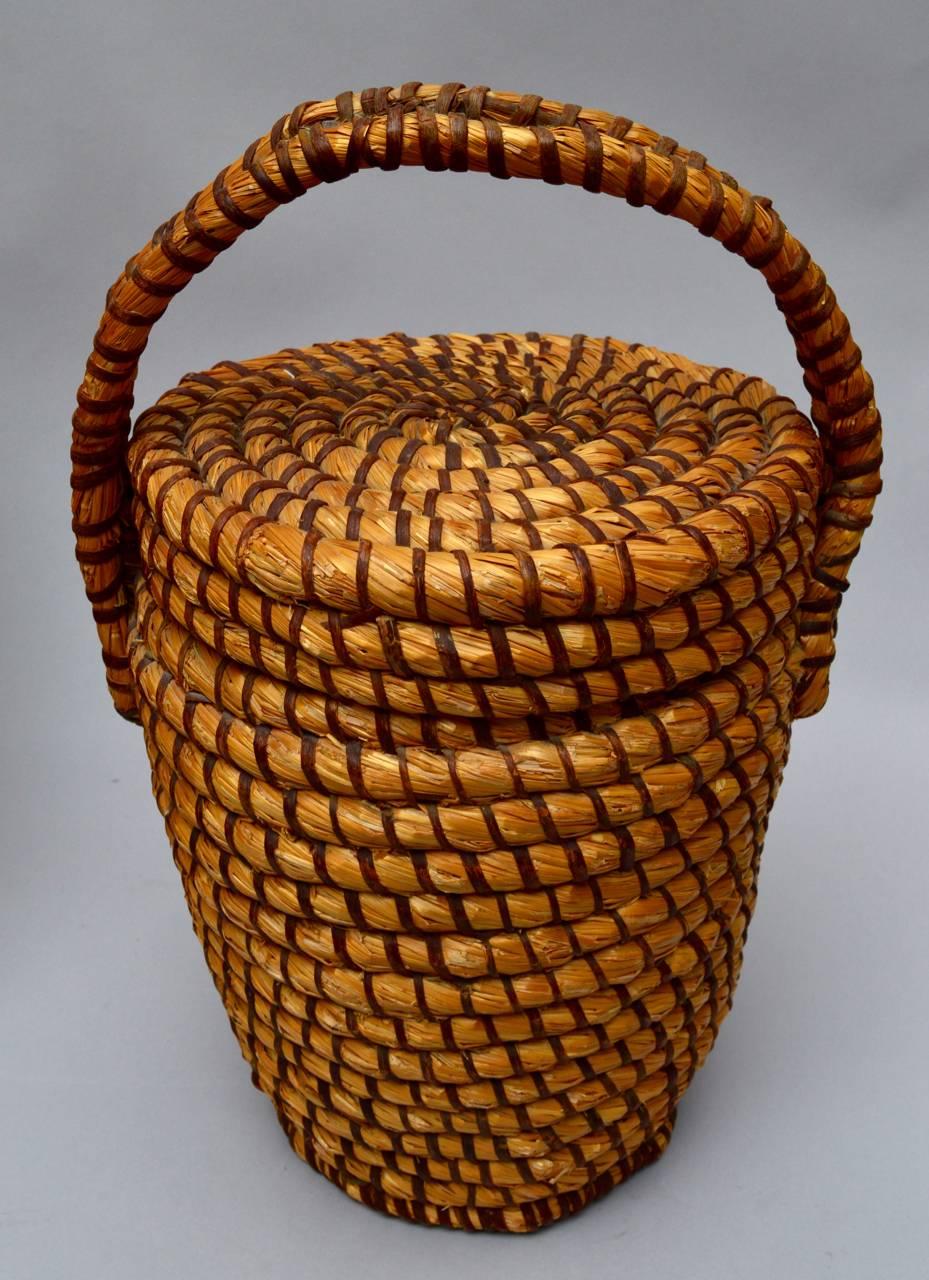 Two 19th century farm baskets hand made from coiled straw and woven split oak. 
Basket with top handle=46 H x 31 W x 26 D cm.
Basket with side handles=42 H x 37 W x 34 D cm.