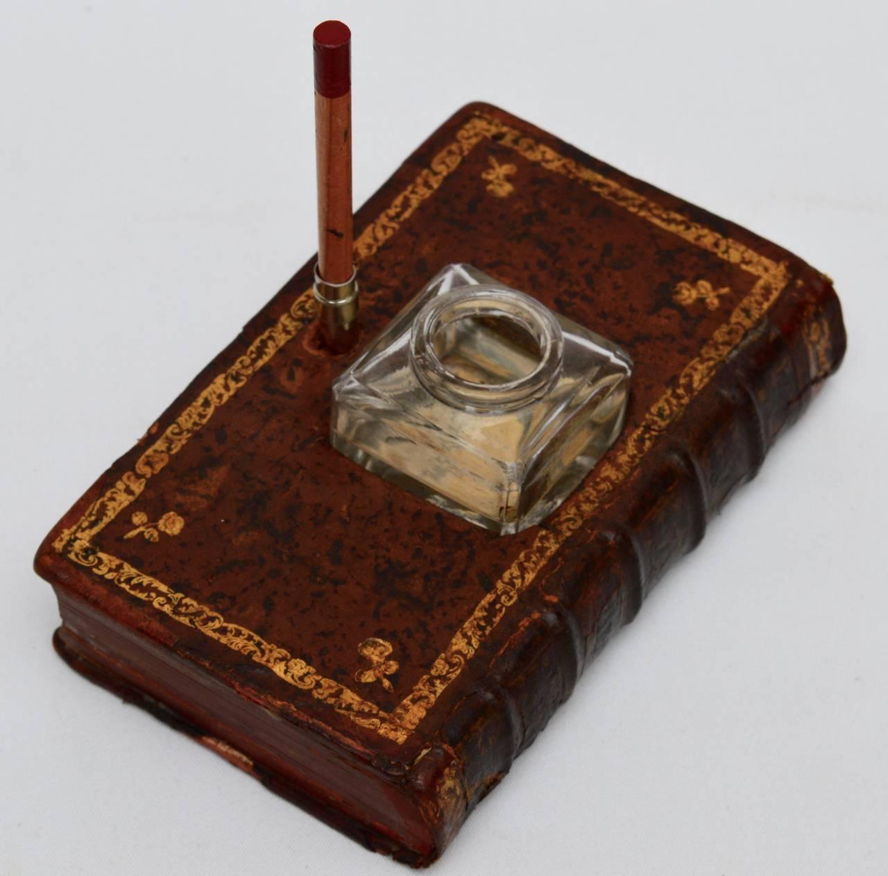 A 19th century French ink well holder artfully made to appear as a leather book. Originally there would have been a feather quill but now there is a pencil. I have shown this piece used as a vase, as this is how I like to use ink wells today.