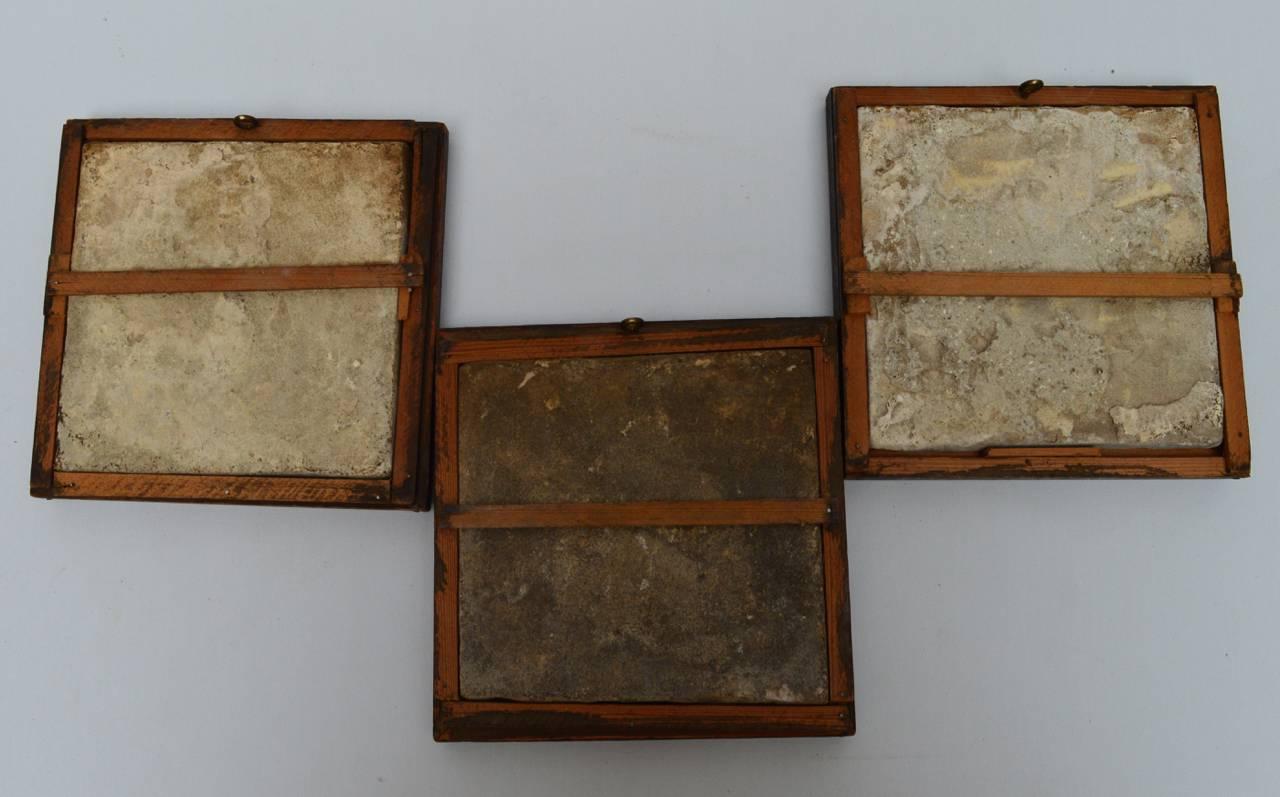 A group of three 18th century blue and white Delft tiles in oak wood frames.
These tiles were removed from a chimney in a canal house kitchen.