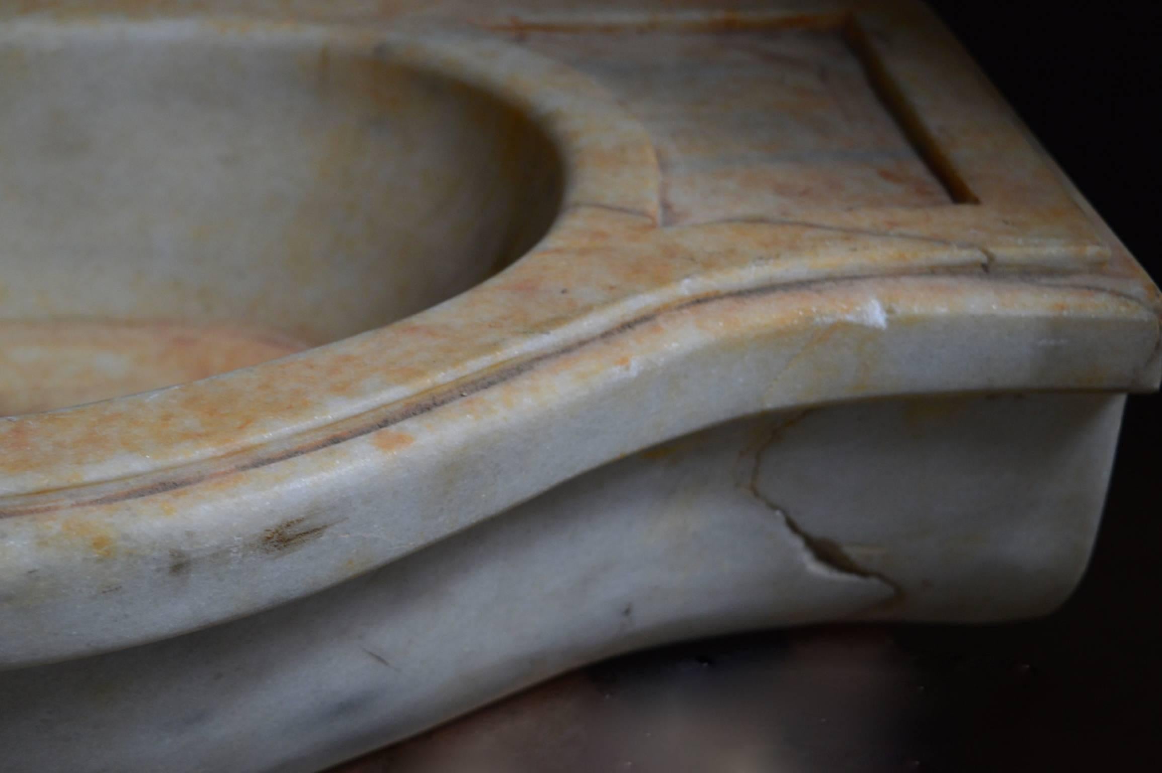 An 18th century Italian sink carved from a solid piece of marble. 
There is a chip on the right underside on a vein that does not affect the structural integrity and adds to the beauty of a piece that is at least 300 years old.