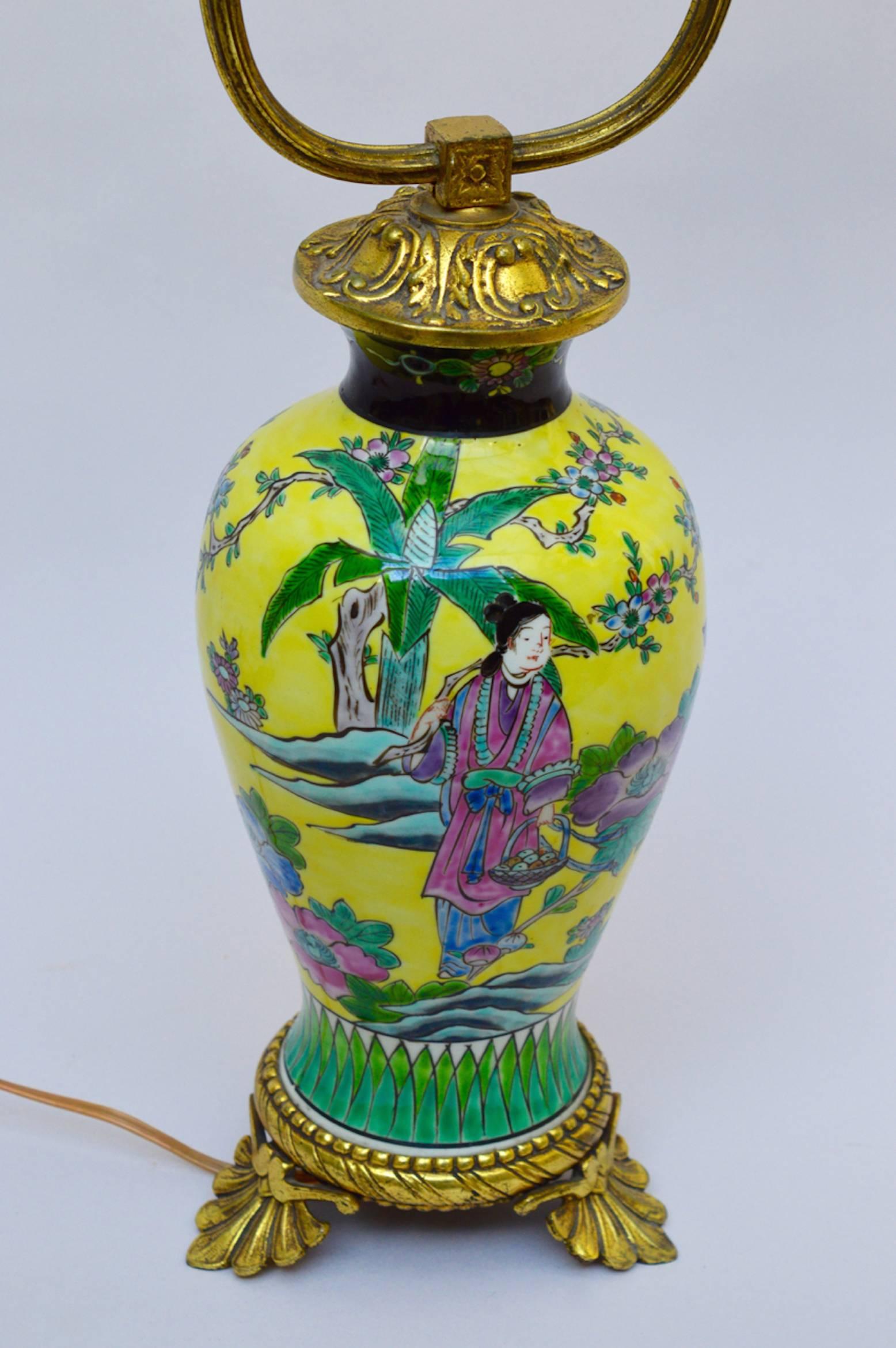 A brilliant yellow Chinese export  glazed porcelain vase converted into a lamp in France in the 1930s.
A tropical Chinese scene is painted in vivid yellow green and pink set off with black and mounted with stylized empire bronze mounts. 
A rare find