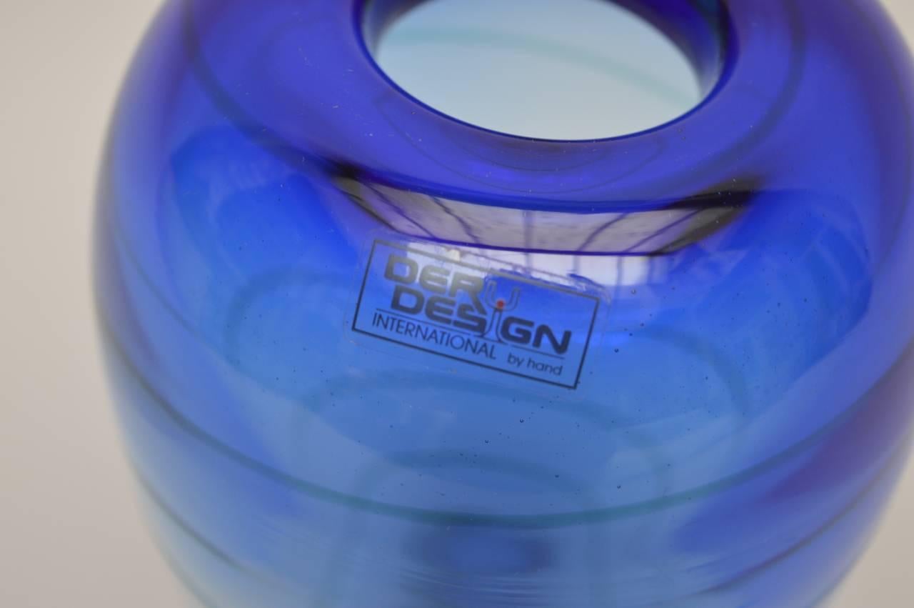 20th century handmade blue swirl glass vase made in Germany by Deru design. The rich deep blue of the top gradually changes into a faint almost clear blue while a green or blue swirl keeps its color and climbs from bottom to top where it