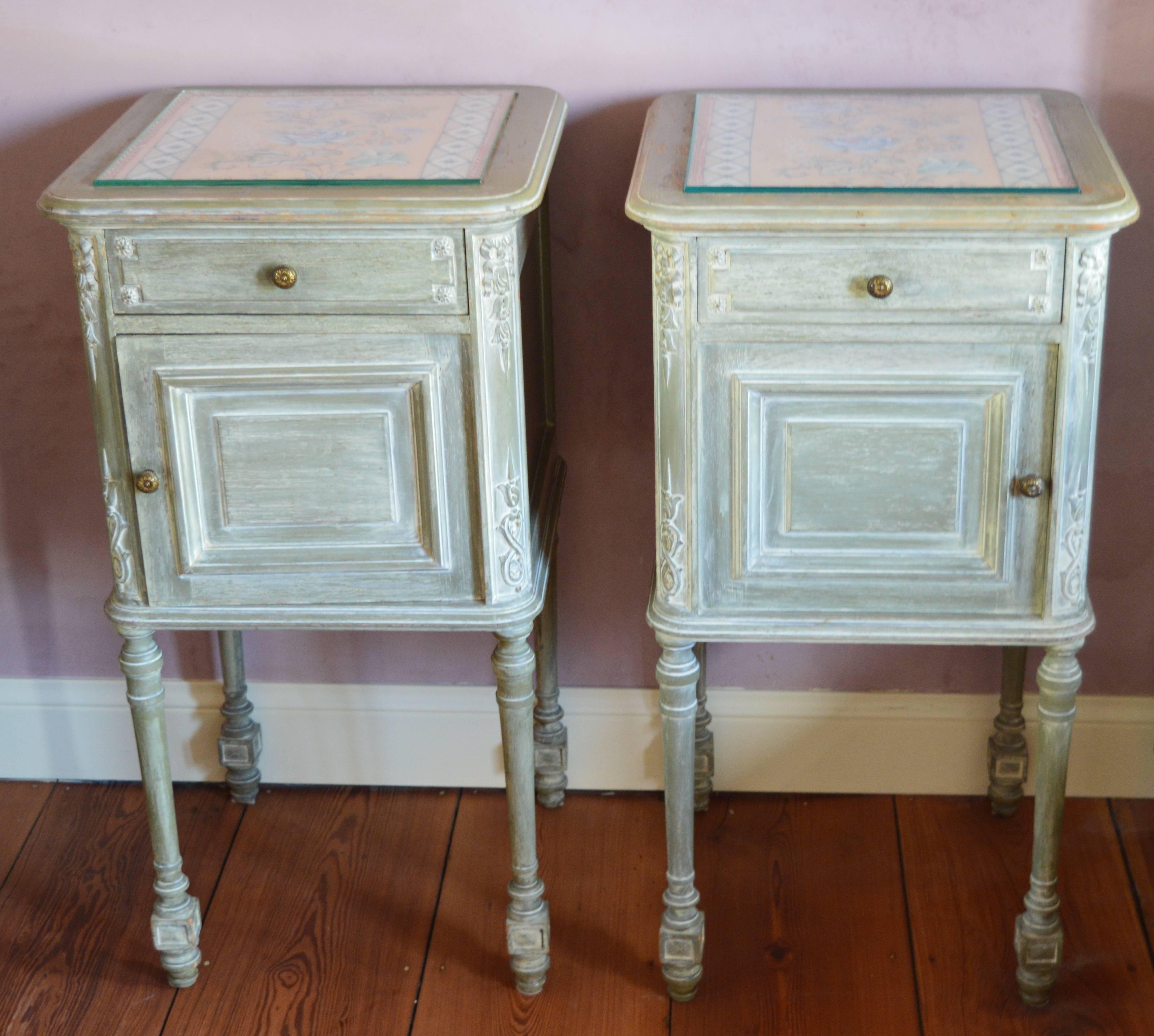 This pair of French Louis XVI style bedside cabinets are in very good condition and retain the original paint and cast bronze knobs.
They are handmade from French white oak and have elegant hand-carved decorations of ribboned swags and foliate