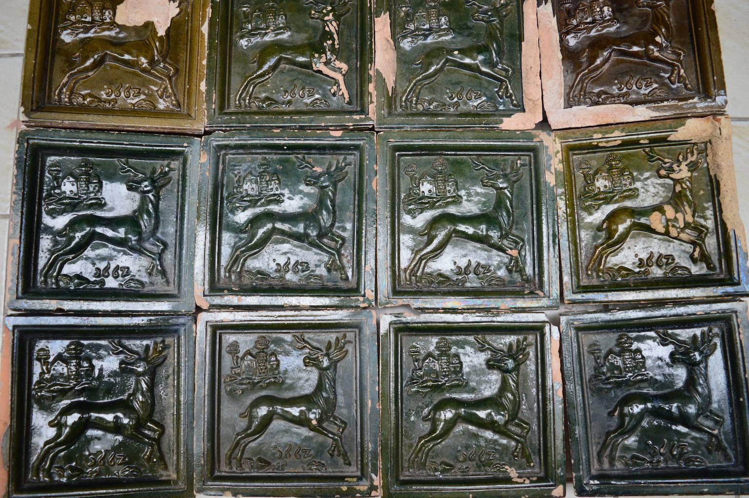 This antique chimney surround is made of 12 glazed green terracotta tiles with a raised relief design showing a reindeer, castle and the date 1667. Stamped on the reverse by the maker 
