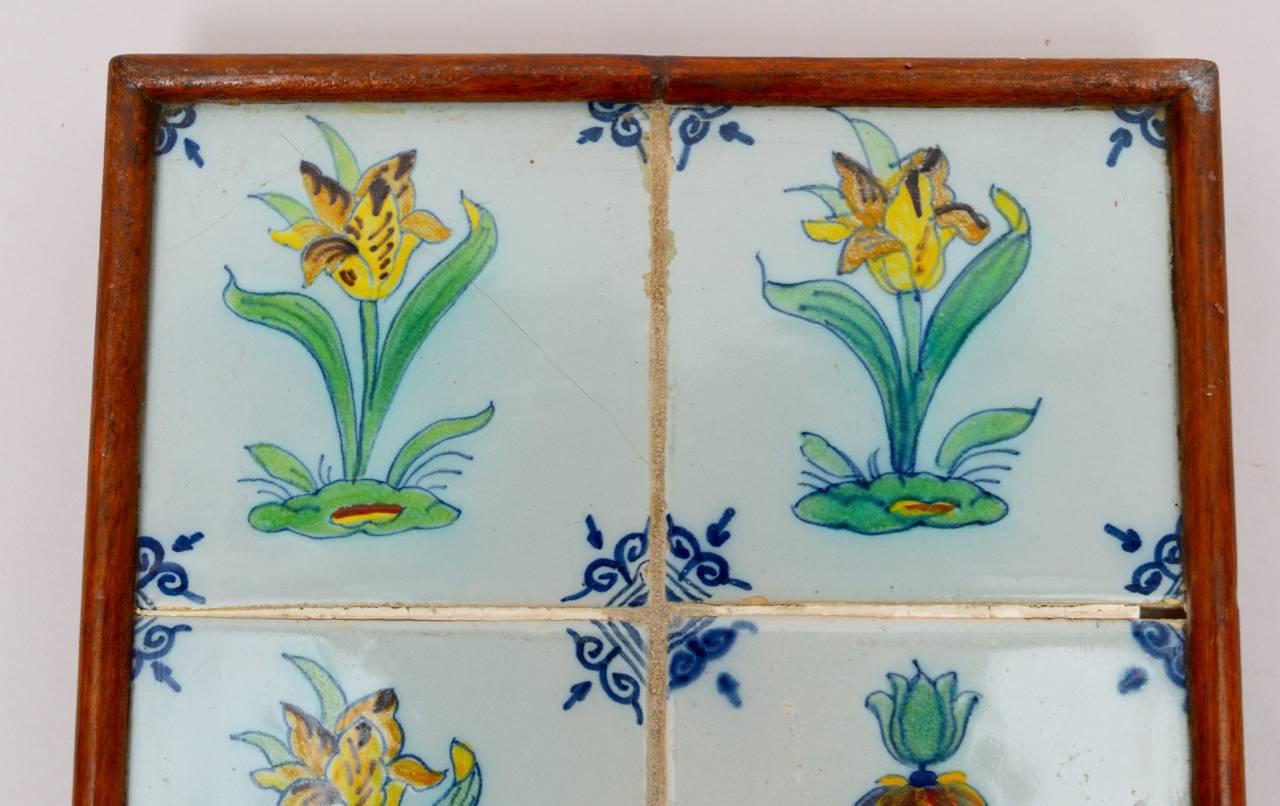 A group of four early 18th century Dutch tiles framed together to be used as a wall plaque or as a hot plate trivet. The tiles are painted showing unusual tulips which were the status symbol of their day.
 