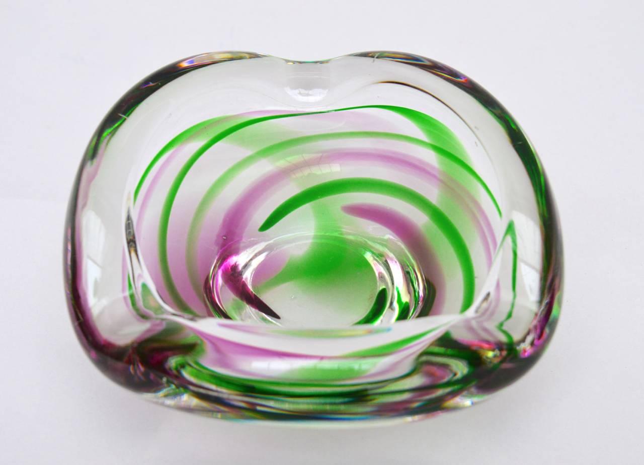 1960s Italian Murano glass bowl in clear class with an encased swirl design in green and lavender. The underside has a hand etched signature. (I cannot read it, but maybe you can).