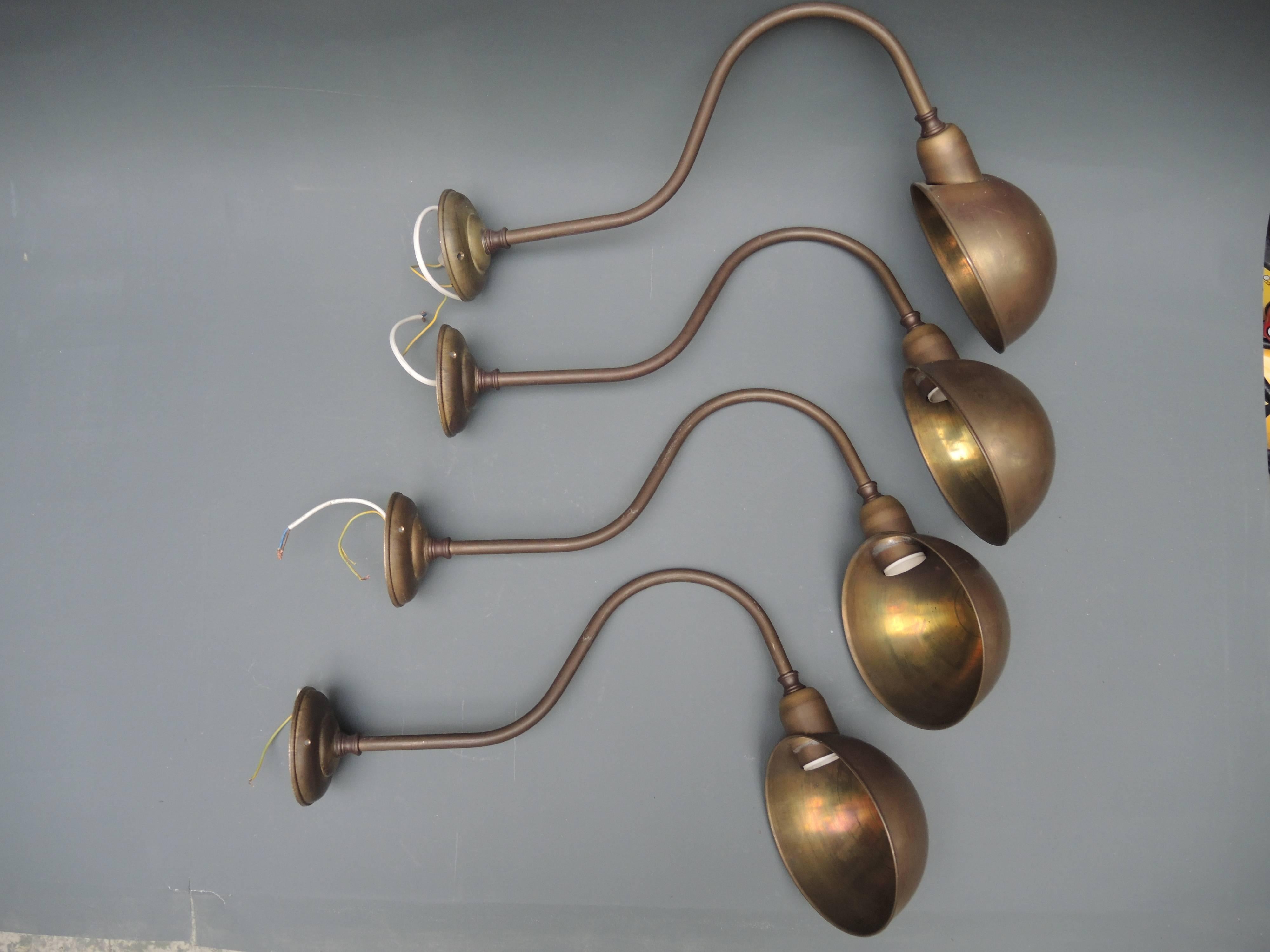 Four 1930s French brass wall lamps to be used to light bookcases or a shop sign. All in very good condition and ready to use.
