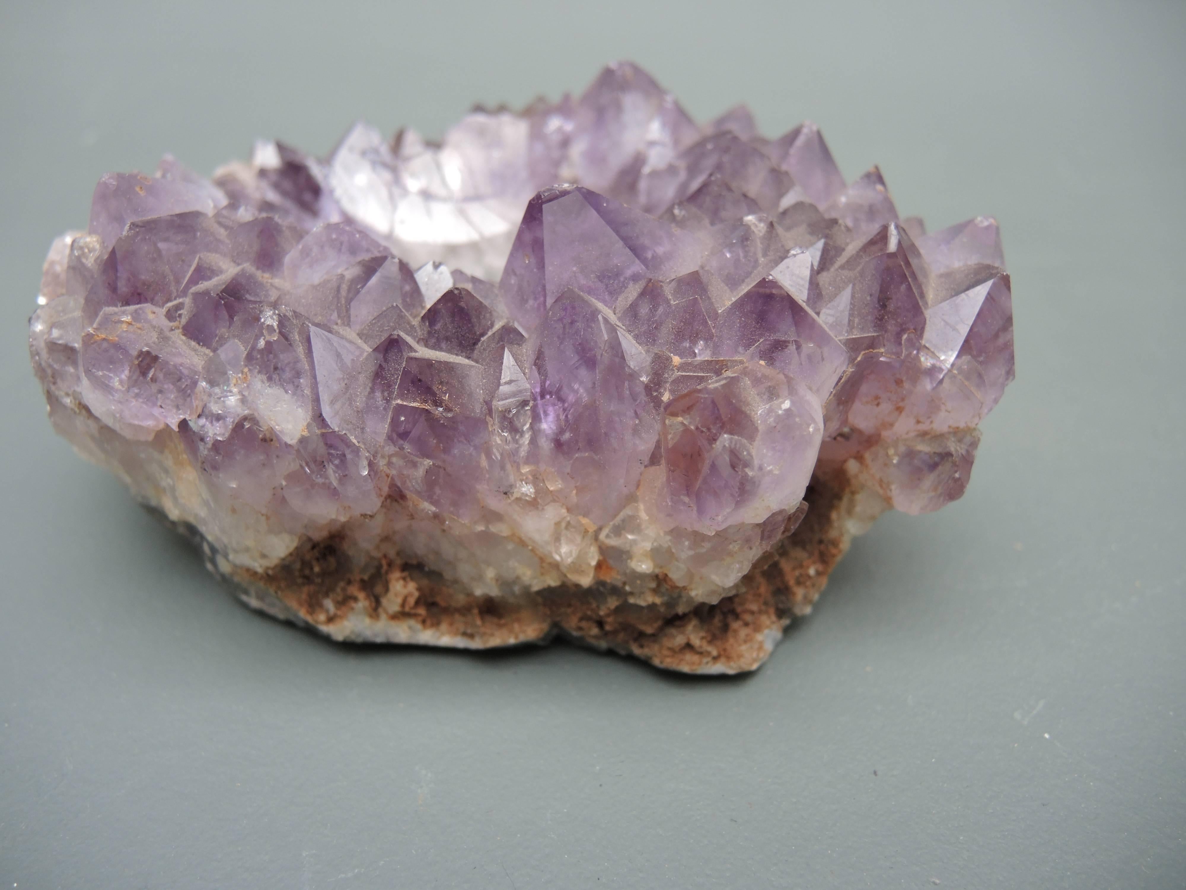 Small bowl carved from amethyst stone geode cluster 1970's in very good condition.
The perfect host/hostess gift to use next to the bed or dressing room to put earrings or cuff links , or to place scented herbs.