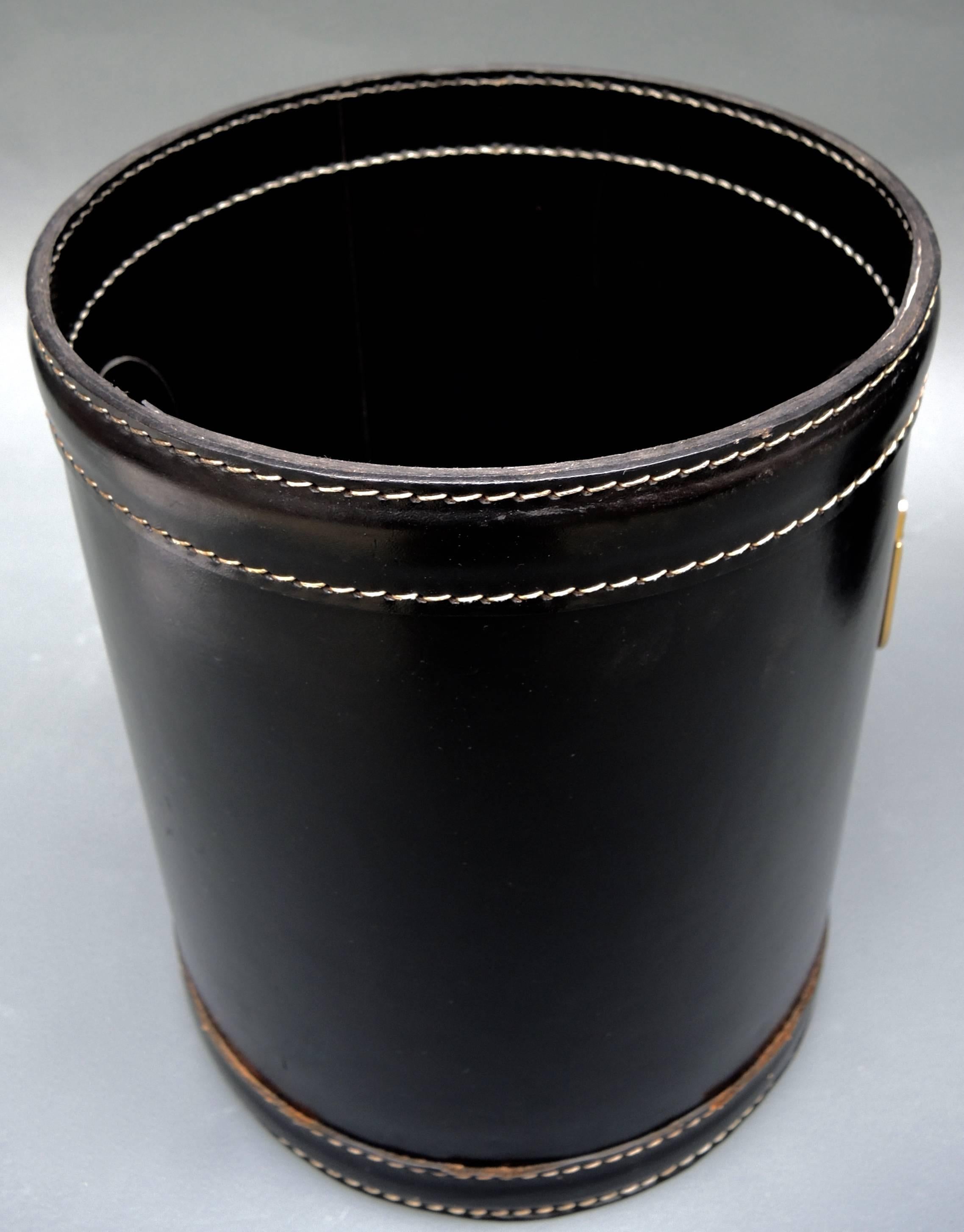 Saddle stitched black leather trashcan with gold washed brass handles,
French, circa 1960.