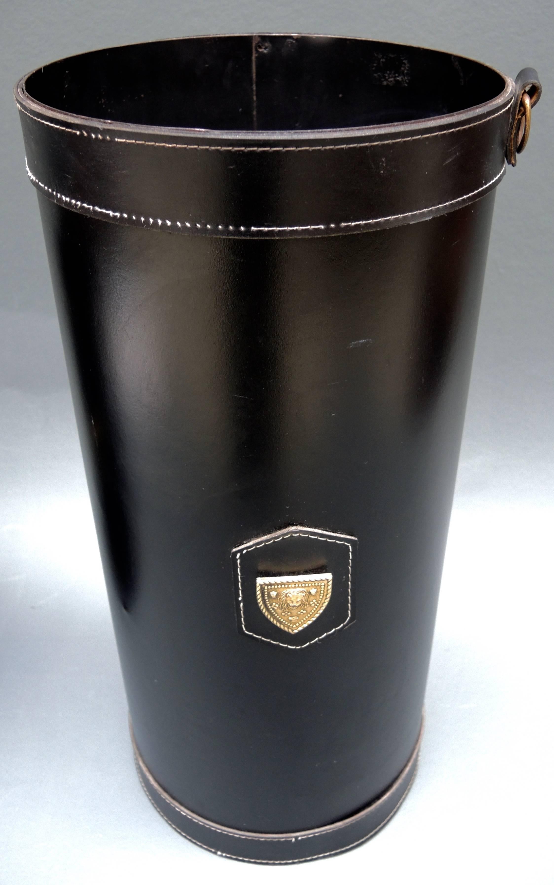 French black leather umbrella stand with saddle stitching and a lion head armorial plaque. Inside there is a removable drip dish.