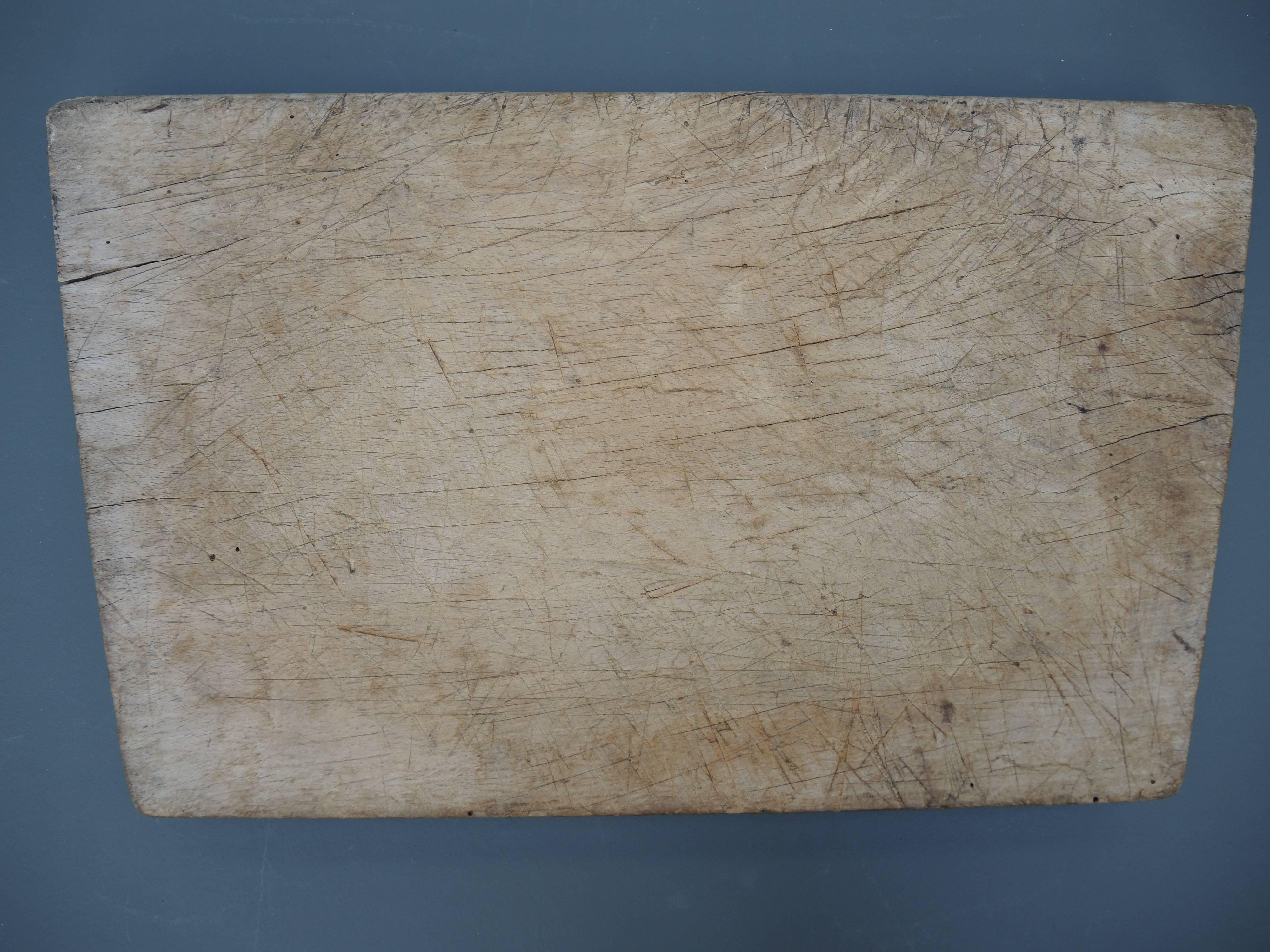 Thick and heavy 19th century wood cutting board. Unusual trapezoid shape and curved centre area from years of use.