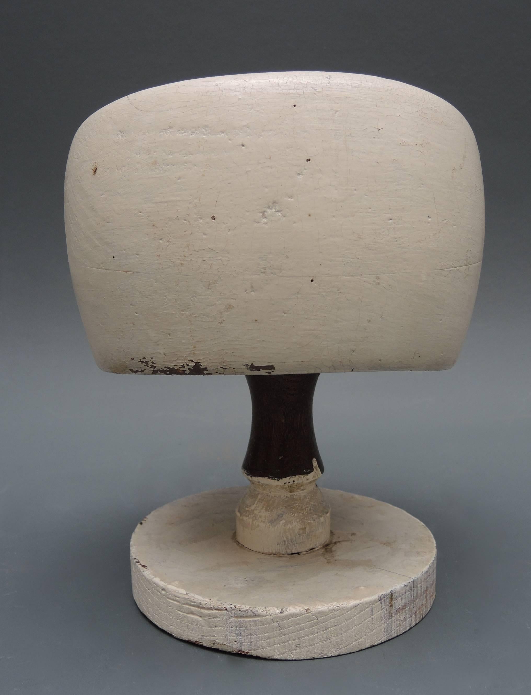 Hand-carved French wood hat block.
This hat form was used by a hat maker to hand form sheets of straw or wool felt using steam to stretch and mold the sheet into the form of the wood mold for the finished hat. Including the original display stand.