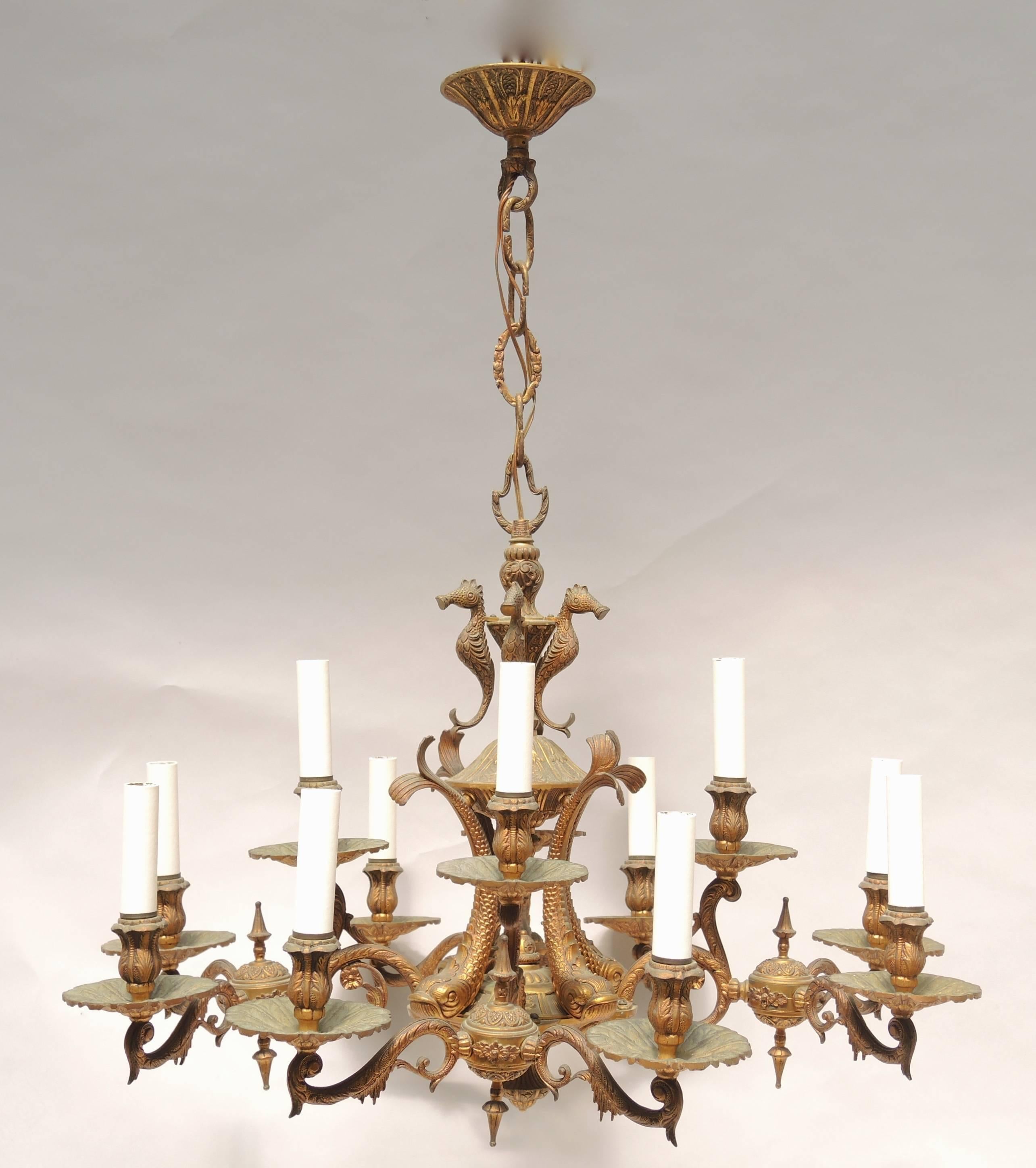 Unusual circa 1930 French cast bronze twelve-arm grotto theme chandelier.
Fine detailed castings of dolphins and seahorses decorate the central column while the twelve arms are cast to mimic the stalactites found hanging from grotto ceilings. A