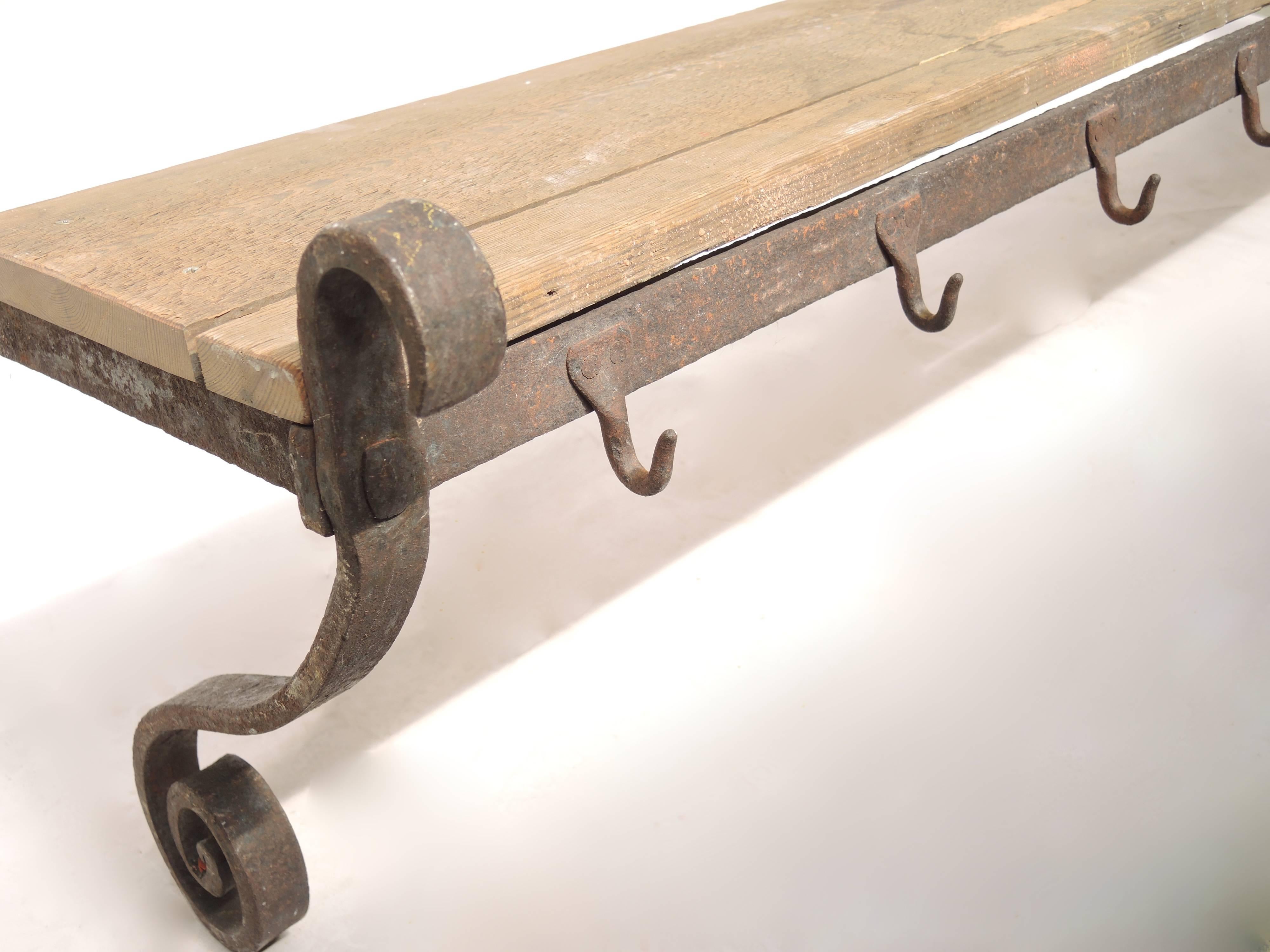 Hand wrought iron butchers/pot rack from the mid 18th Century. The perfect piece to place plates, pots etc on the shelf, and hang pots, herbs, meats ...
The rack was originally anchored into a brick wall from long pins running from the side;for more