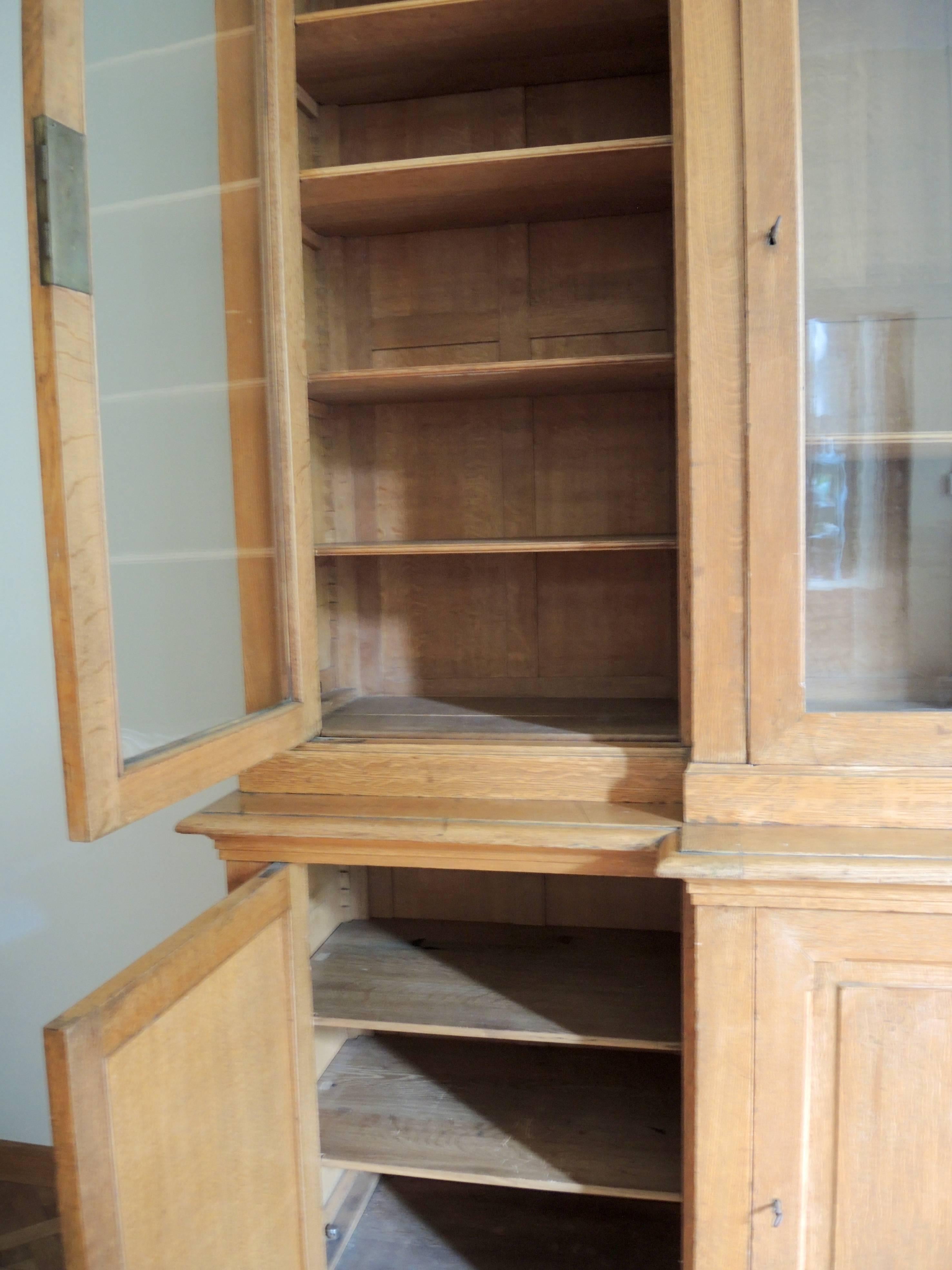 This 19th century Belgian bookcase retains the original blown glass door panels and locks. The original stepped shelf bracket system makes the shelves easily adjustable to your desired height without using any tools. Constructed in solid faded oak