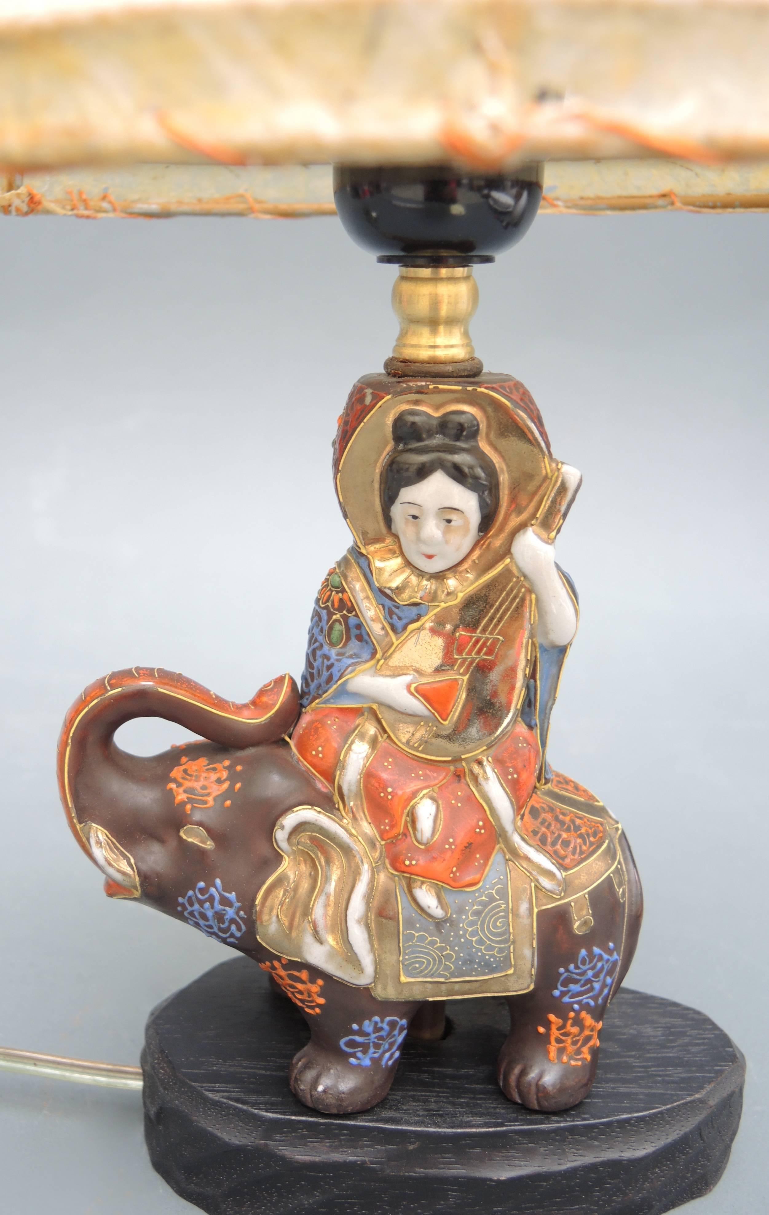 A lovely table lamp made from a small Satsuma porcelain statue of the Goddess Kwan Yin on an elephant and mounted on a wood base. The lamp dates to the early 1940s and retains the original stretched parchment lampshade.
Newly wired and ready to use.
